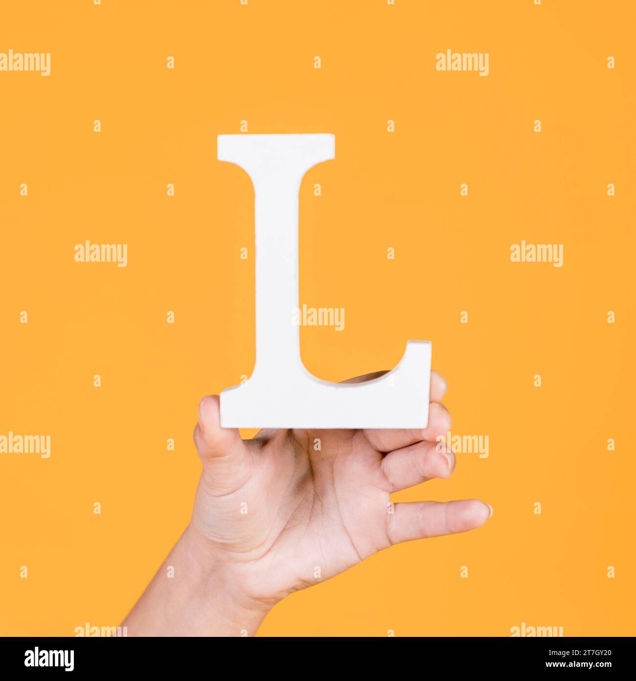 Human hand holding alphabet l Stock Photo