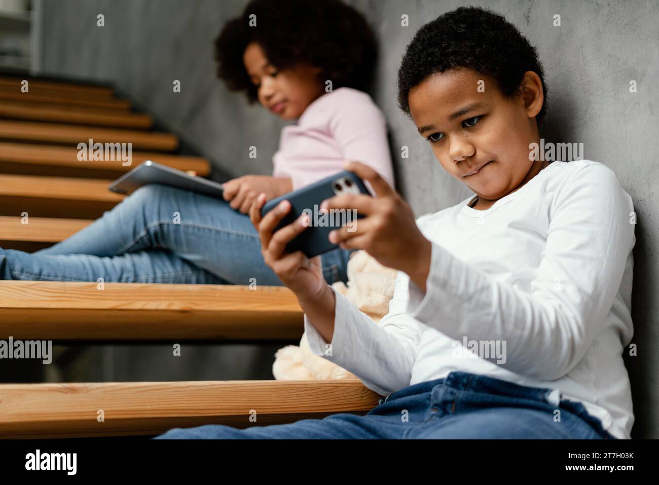 Siblings home using mobile tablet Stock Photo