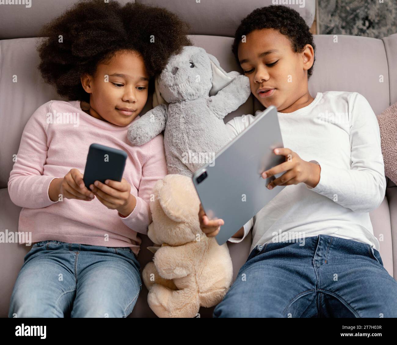 Siblings using tablet mobile home Stock Photo