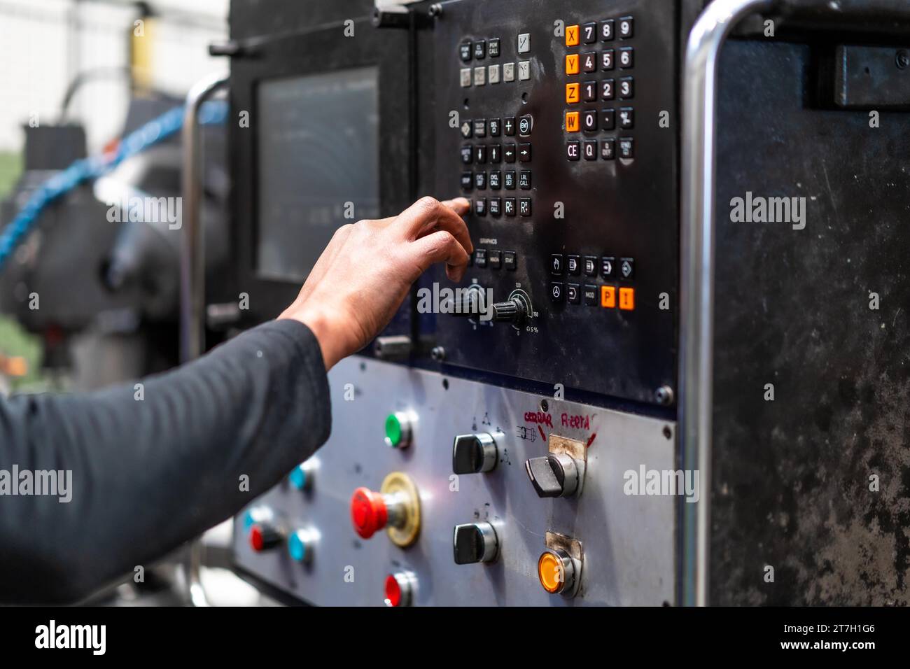 Unrecognizable operator touching the panel of a numerically controlled ...