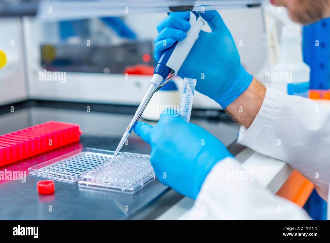 Closeup photo of the hands of a scientist pipetting medical samples