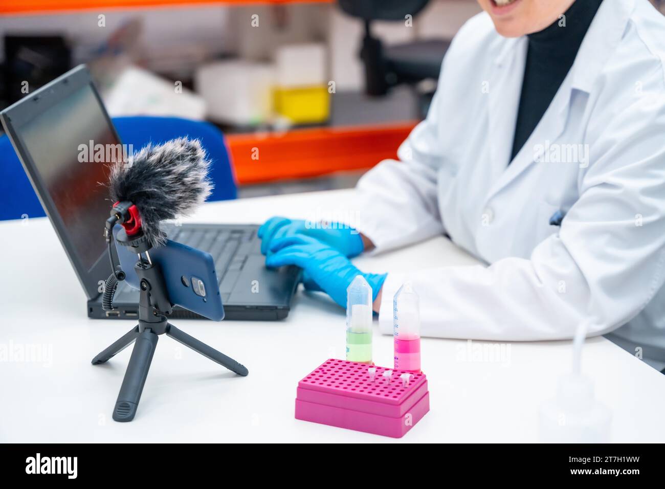 Scientists using mobile to recording while talking next to samples and using laptop in a research laboratory Stock Photo