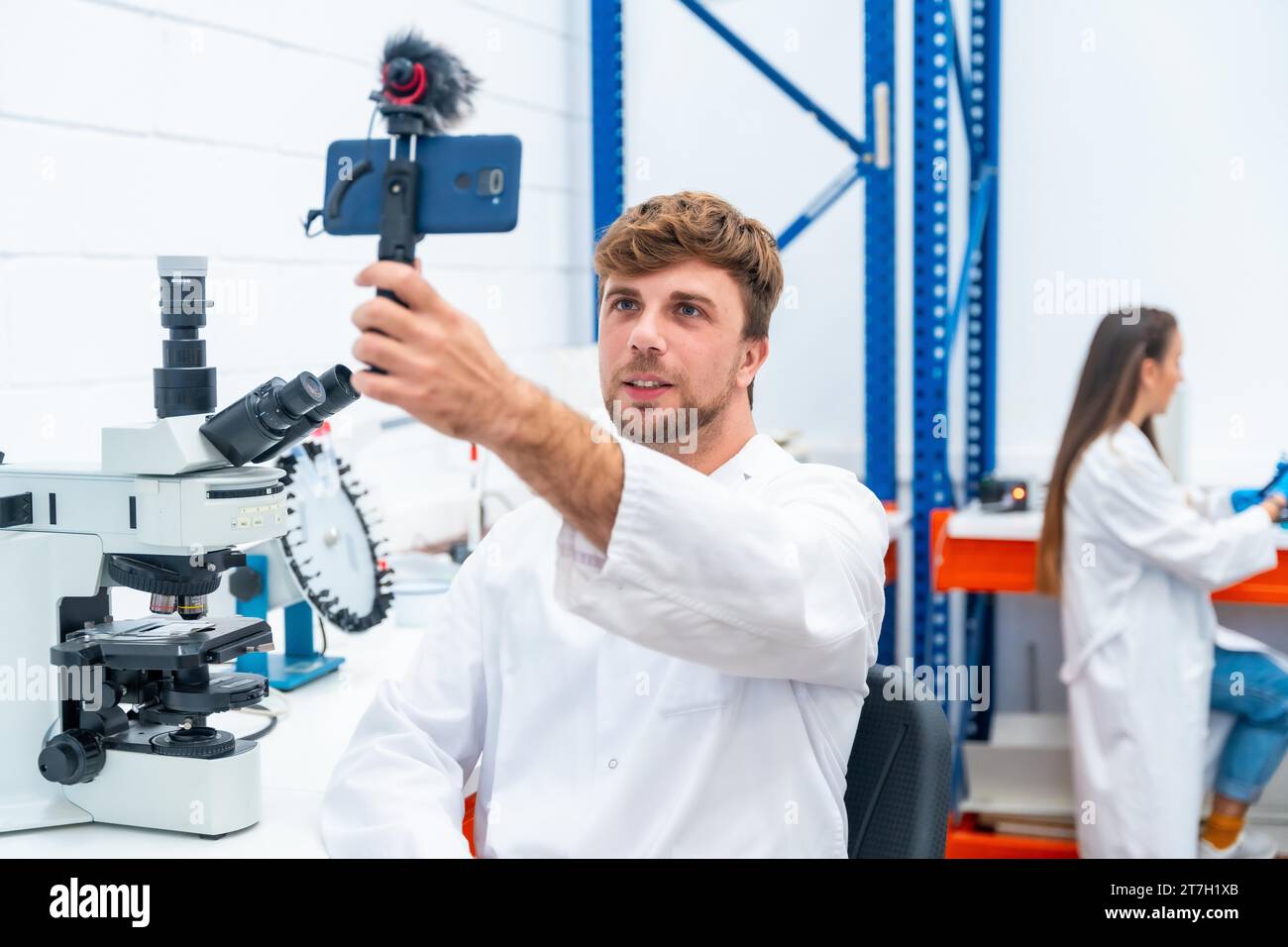 Young and Handsome scientist recording a video using phone inside a research laboratory Stock Photo