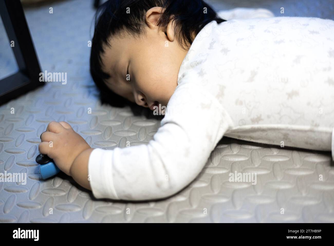 Little baby boy lying on the floor. Boy Sleeping On Floor With Car Toy
