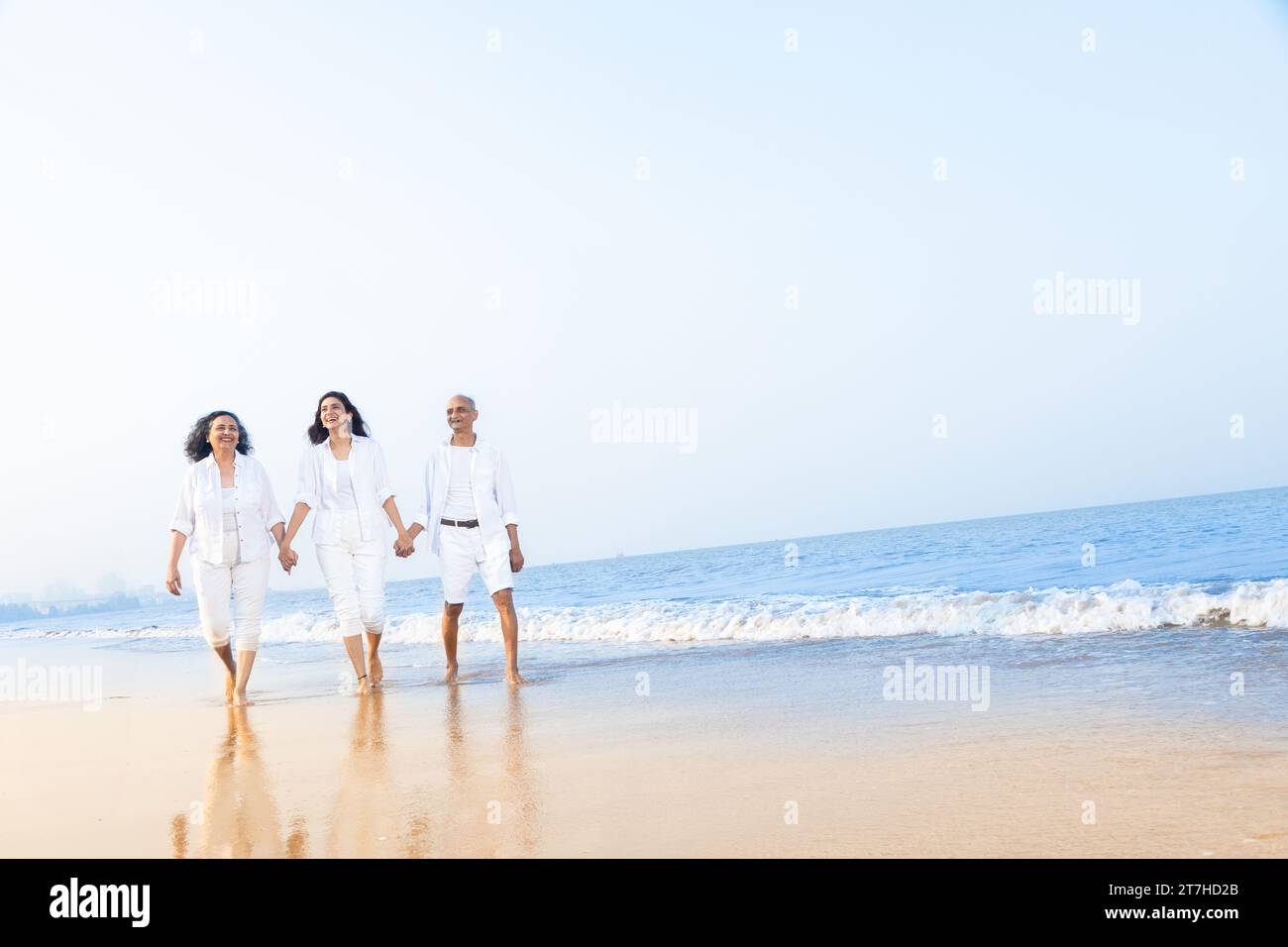 Happy senior indian couple with beautiful young daughter enjoying vacation at beach. Copy space Stock Photo