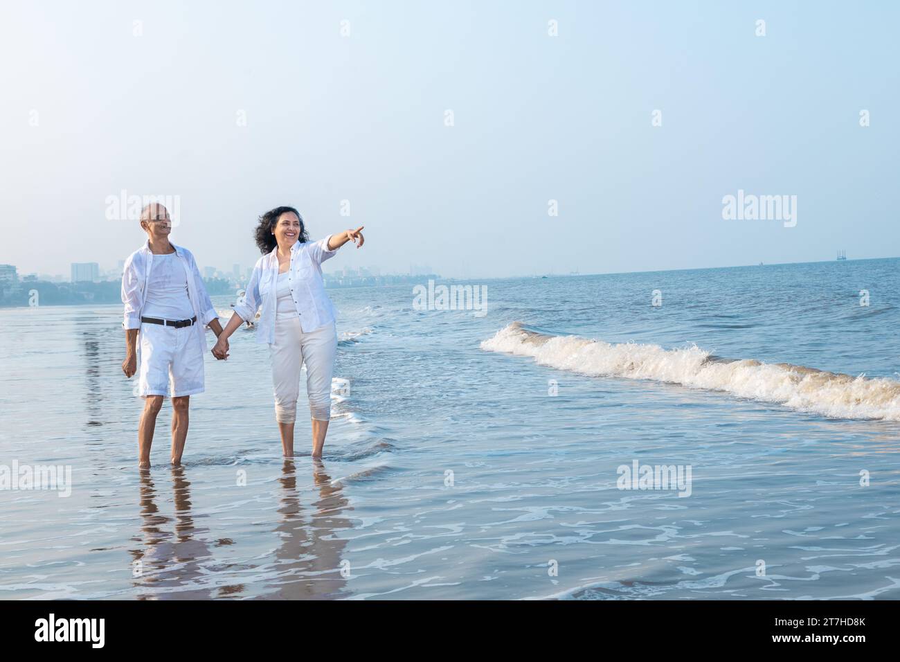 Happy senior indian couple enjoying summer vacation, holiday at beach. Copy space Stock Photo