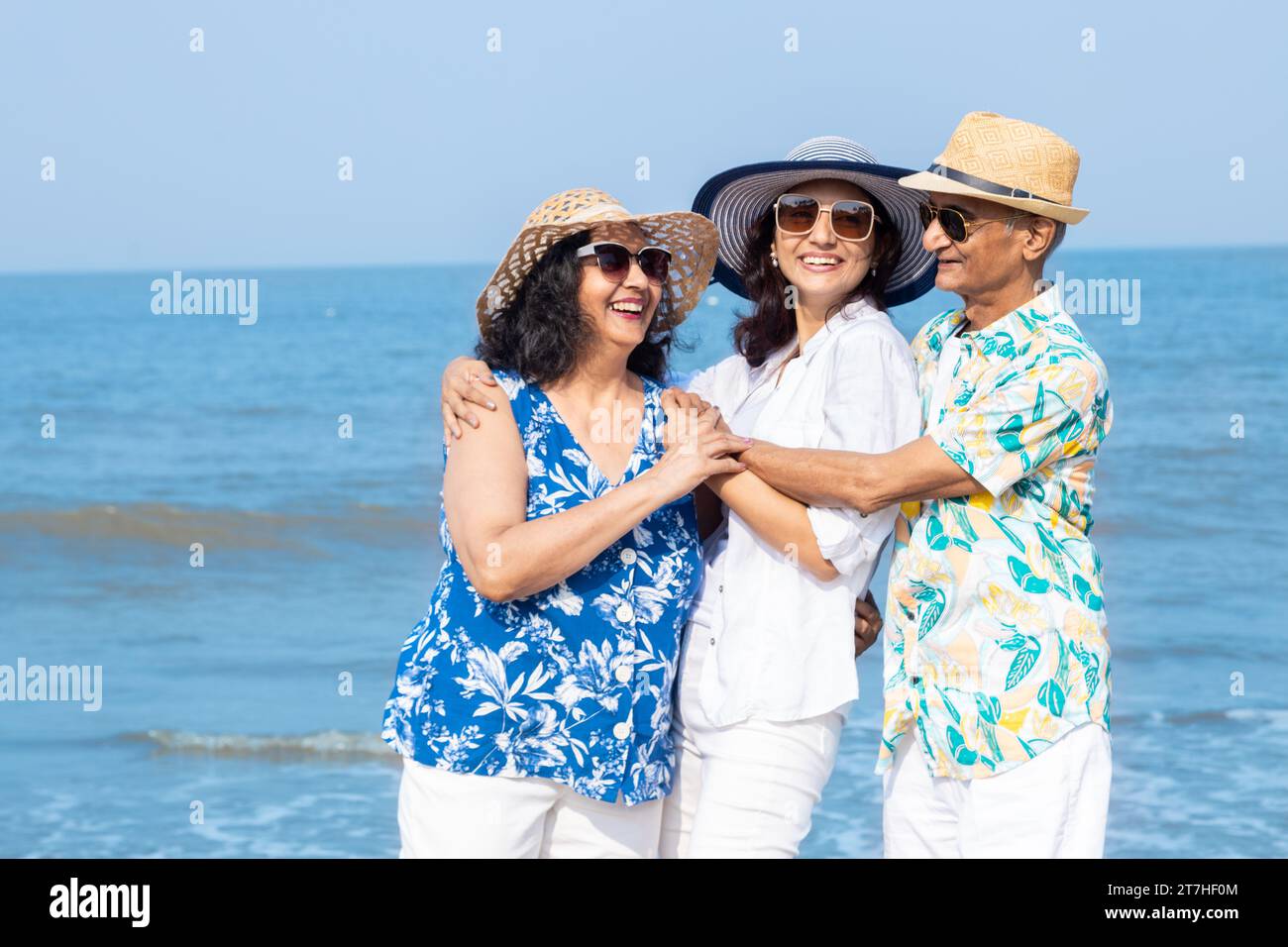 Happy senior indian couple with young daughter enjoying vacation at beach. Family having fun outdoor. Stock Photo