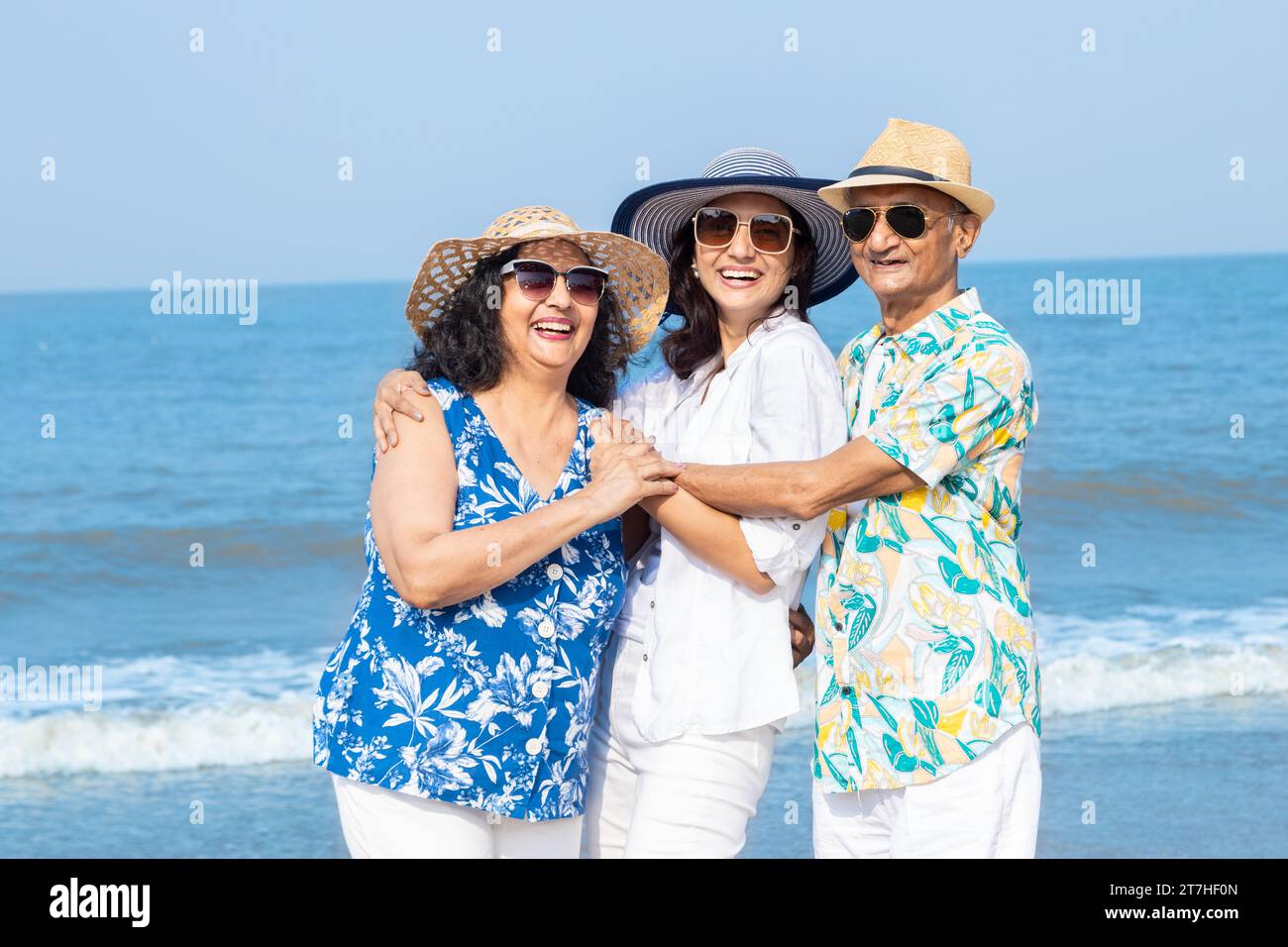 Happy senior indian couple with young daughter enjoying vacation at beach. Family having fun outdoor. Happy senior indian couple with young daughter e Stock Photo