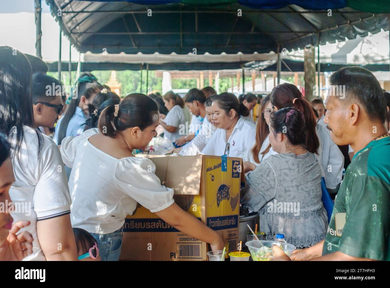 SURATTANI, THAILAND- NOV. 06, 2023: People waiting to receive food distribution to people coming to the Kathin merit-making festival in Thailand Stock Photo