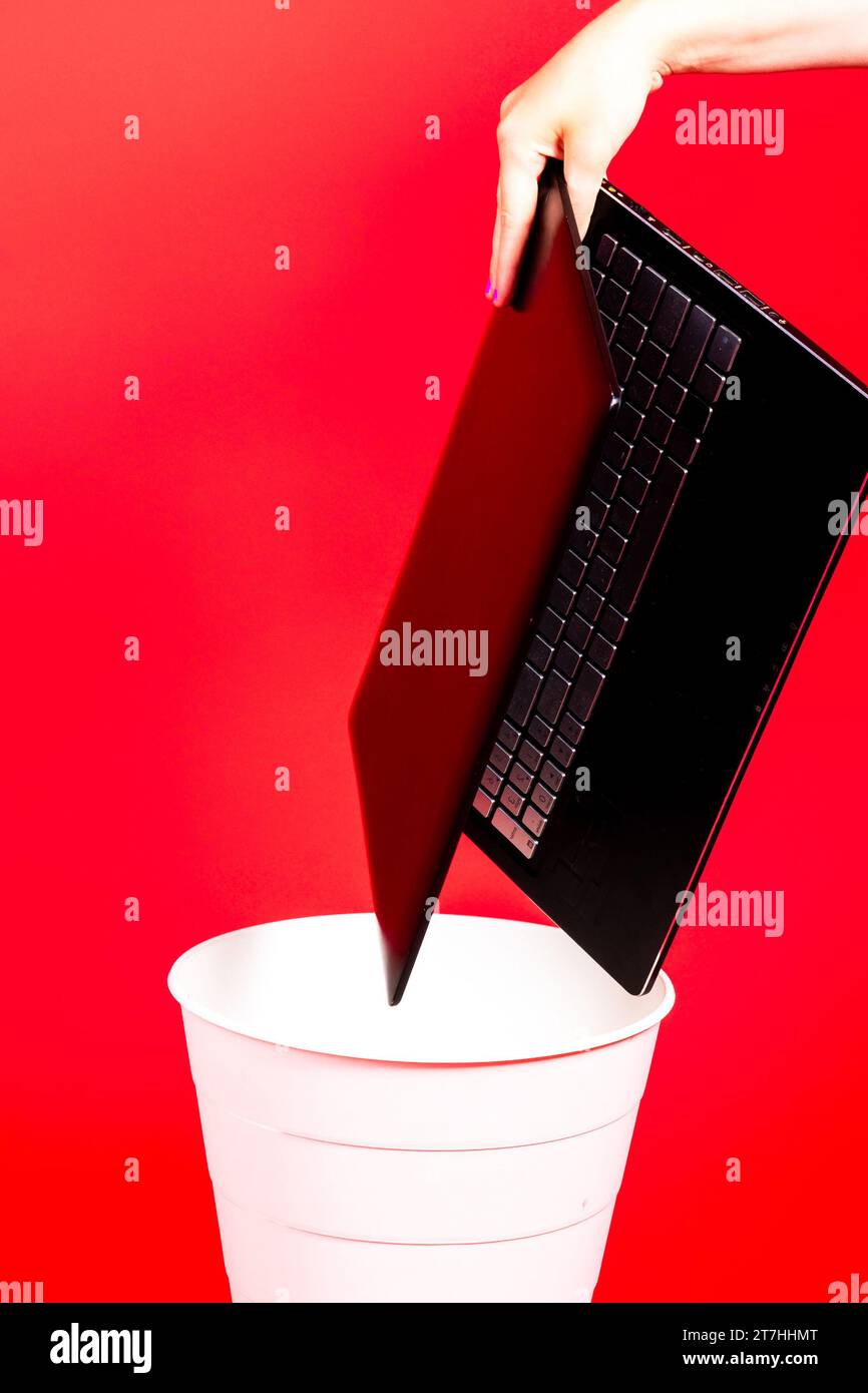 Black laptop in a trash bin on a red background isolated Stock Photo Alamy