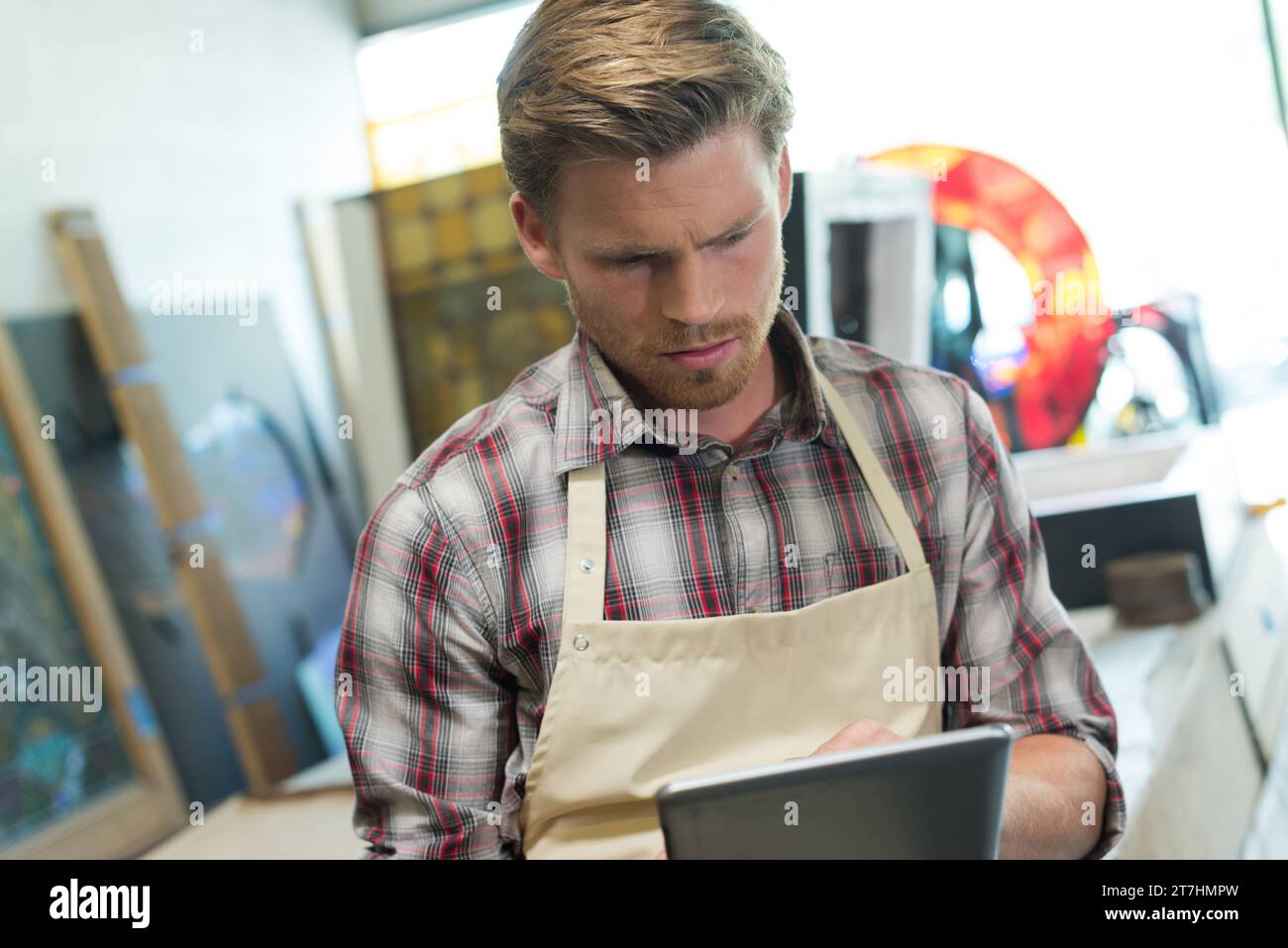shoemaker using digital tablet in workshop Stock Photo