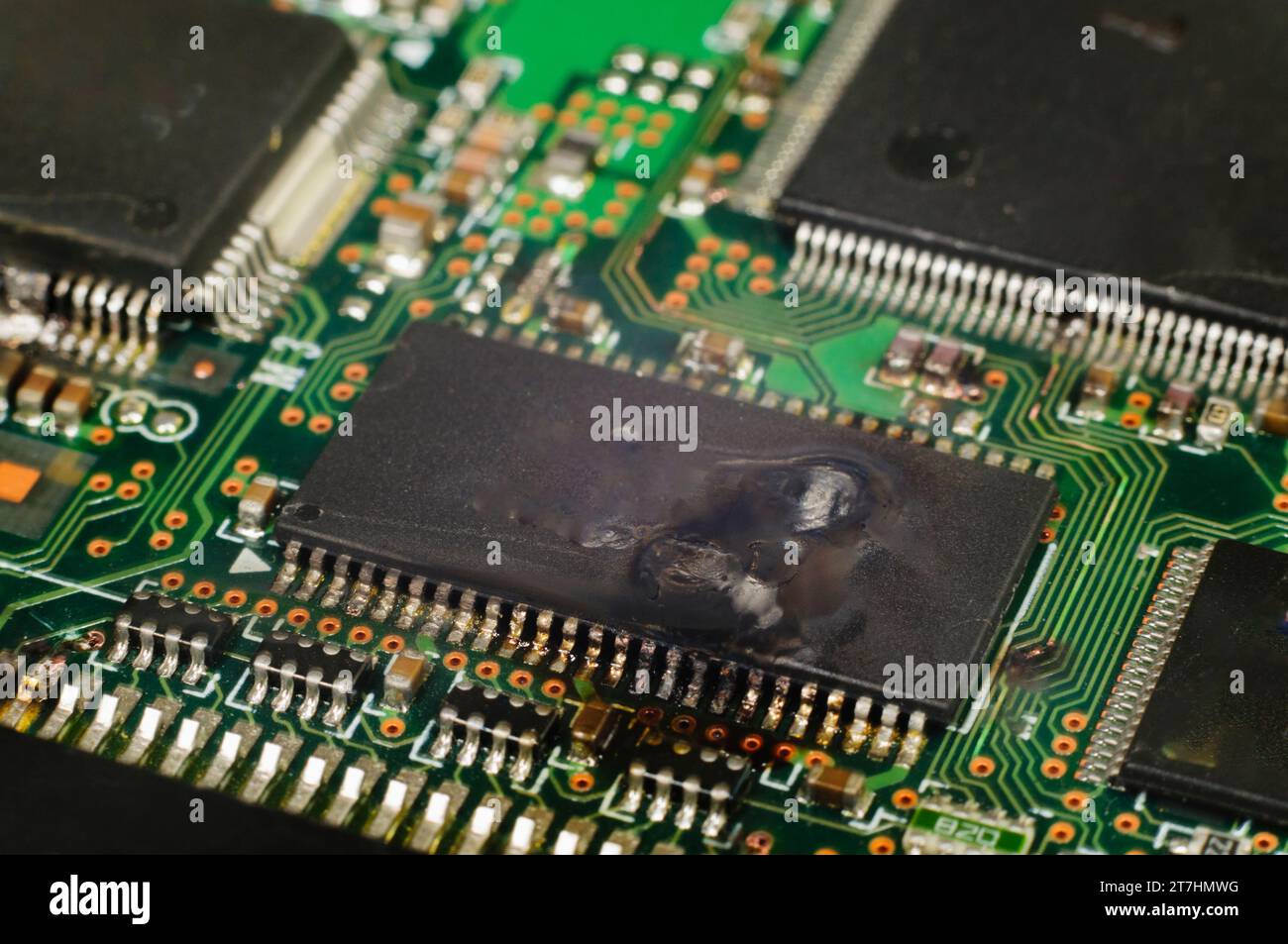 Electronic integrated circuit (IC) on a computer PCB after suffering a ...