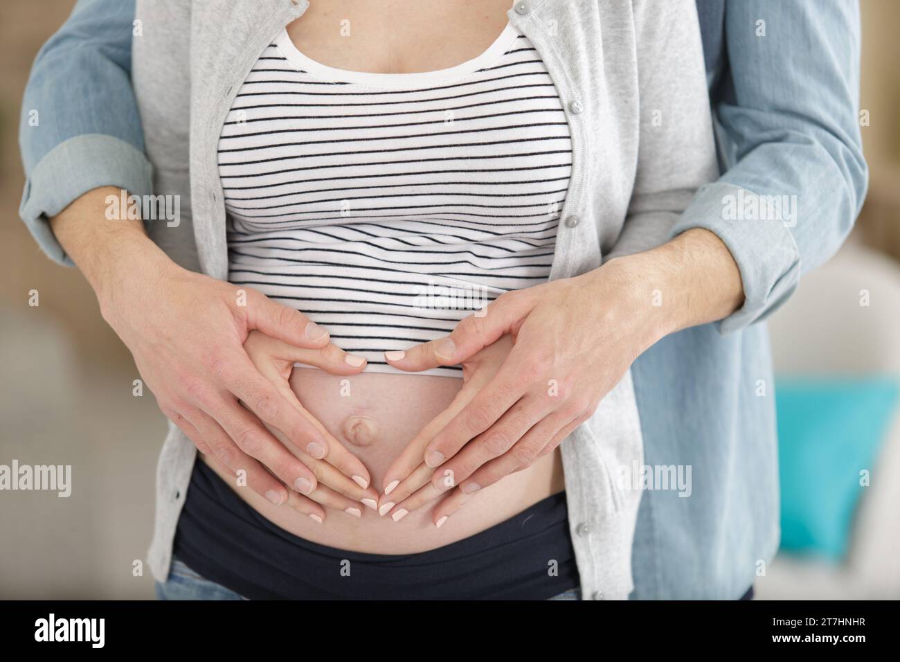 couple making hearts with their hands on pregnant belly Stock Photo Alamy
