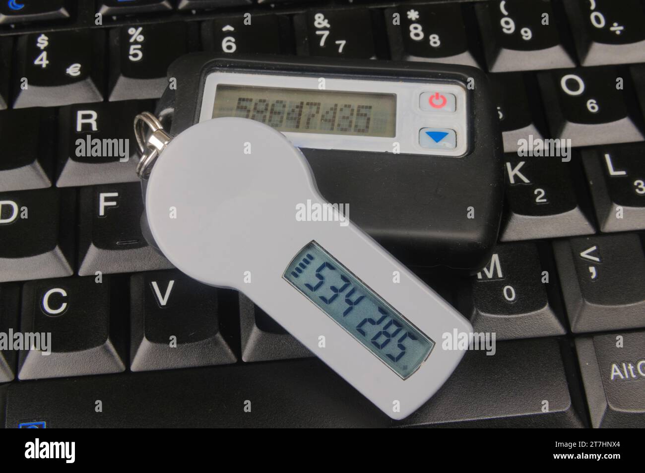 Two SecureID Tokens sitting on a computer keyboard Stock Photo