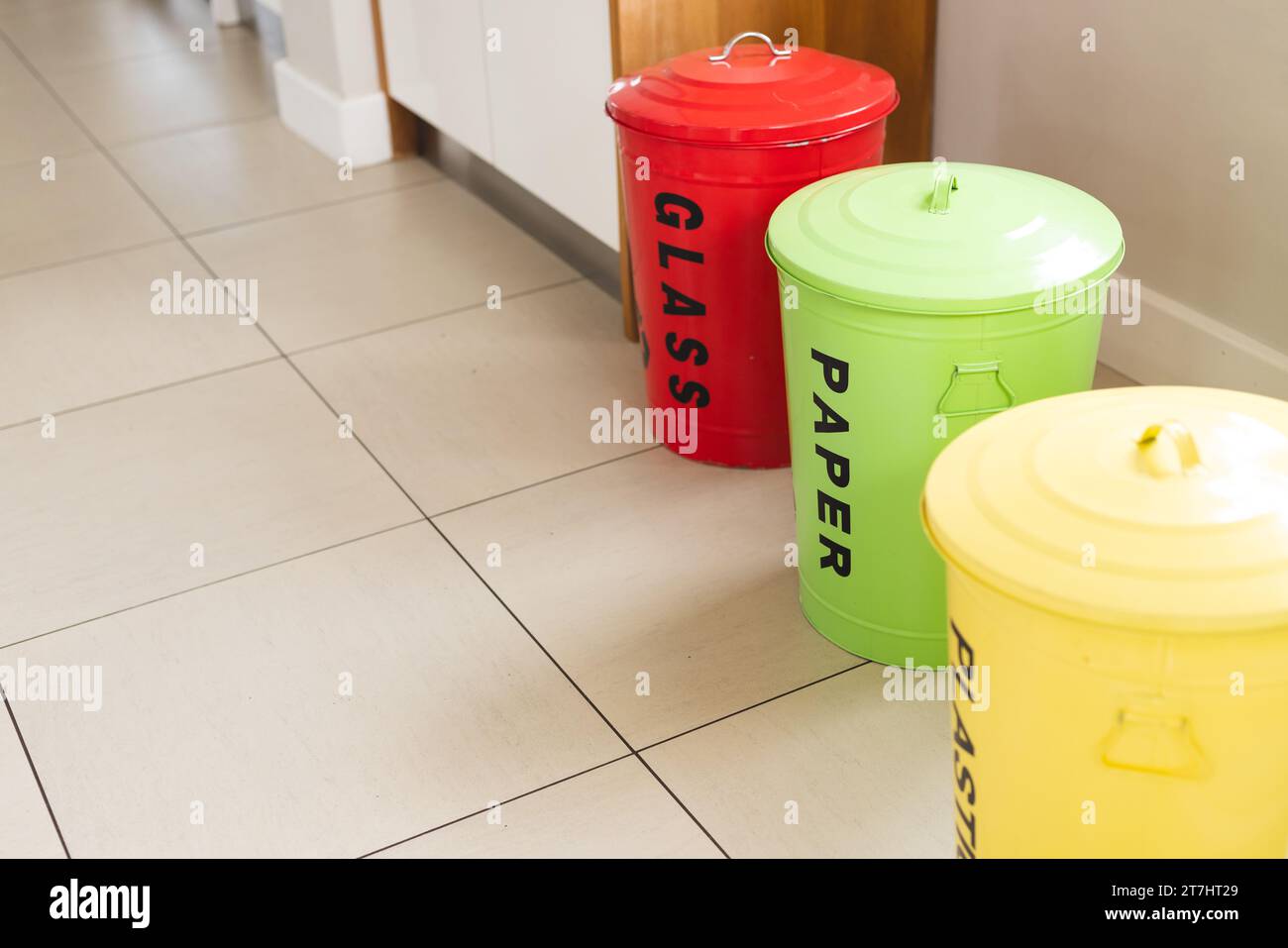 Colourful waste sorting bins standing in sunny kitchen at home Stock