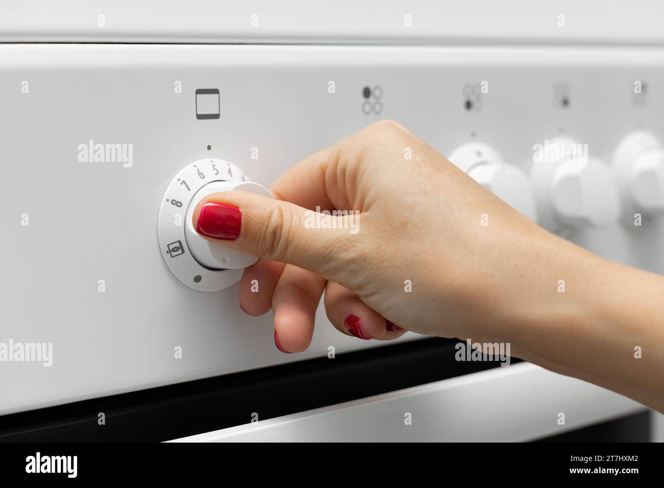 woman turns on the oven in a gas stove. oven temperature selection