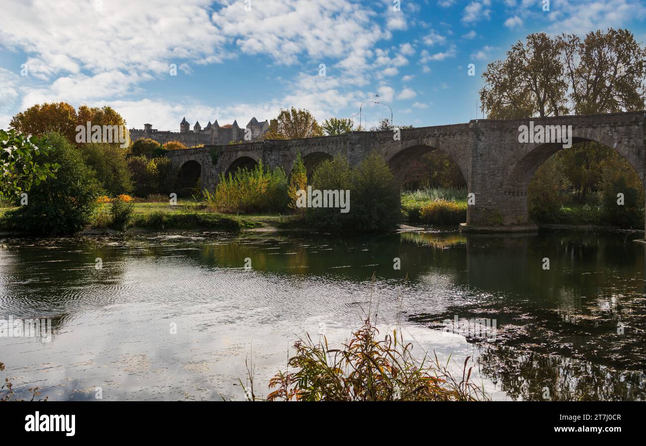 The old bridge and in the background the city of Carcassonne, and the Aude river, in Aude, in Occitanie, France. Stock Photo
