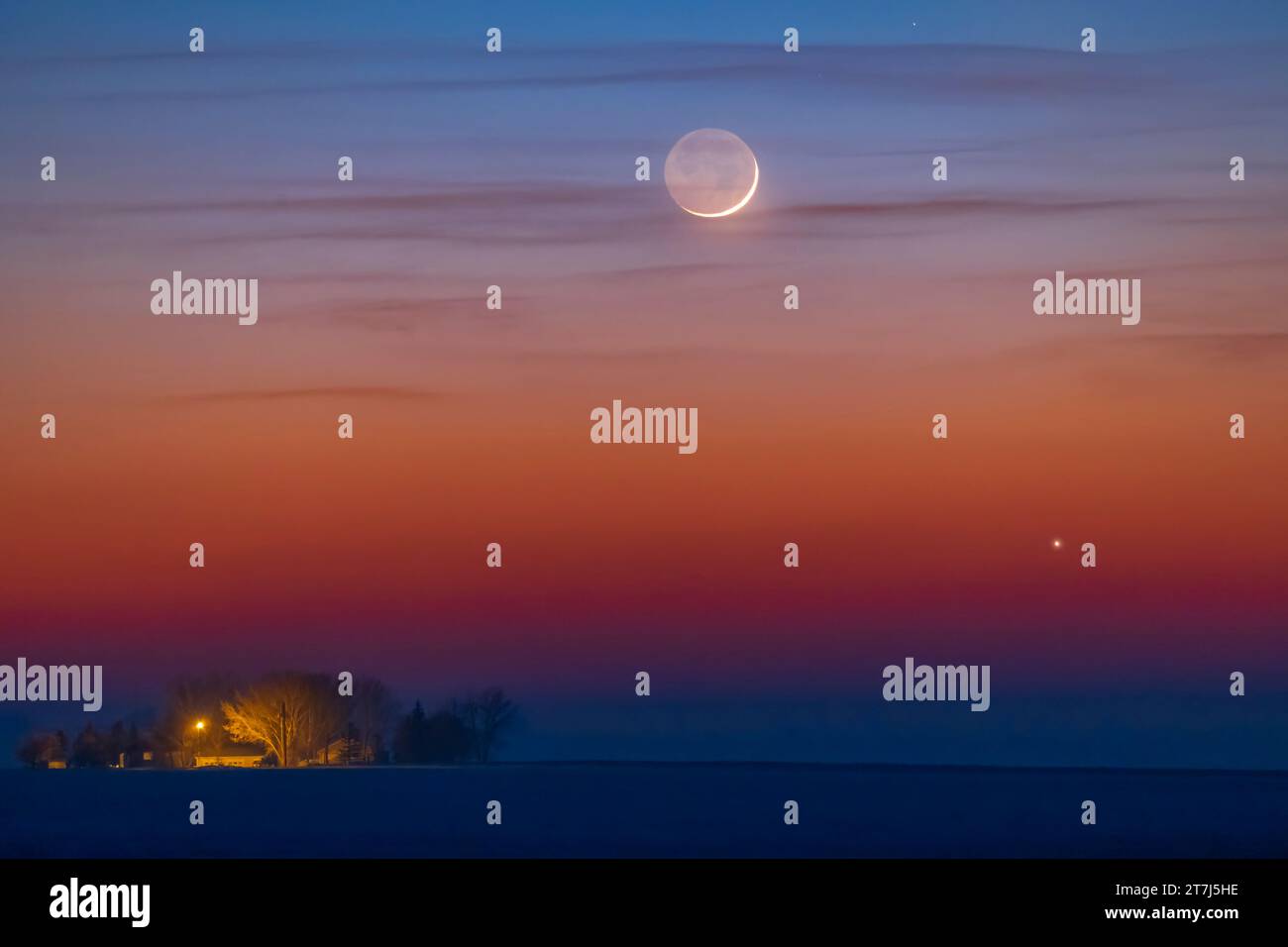 The thin one-day-old crescent Moon just above Jupiter as both set on