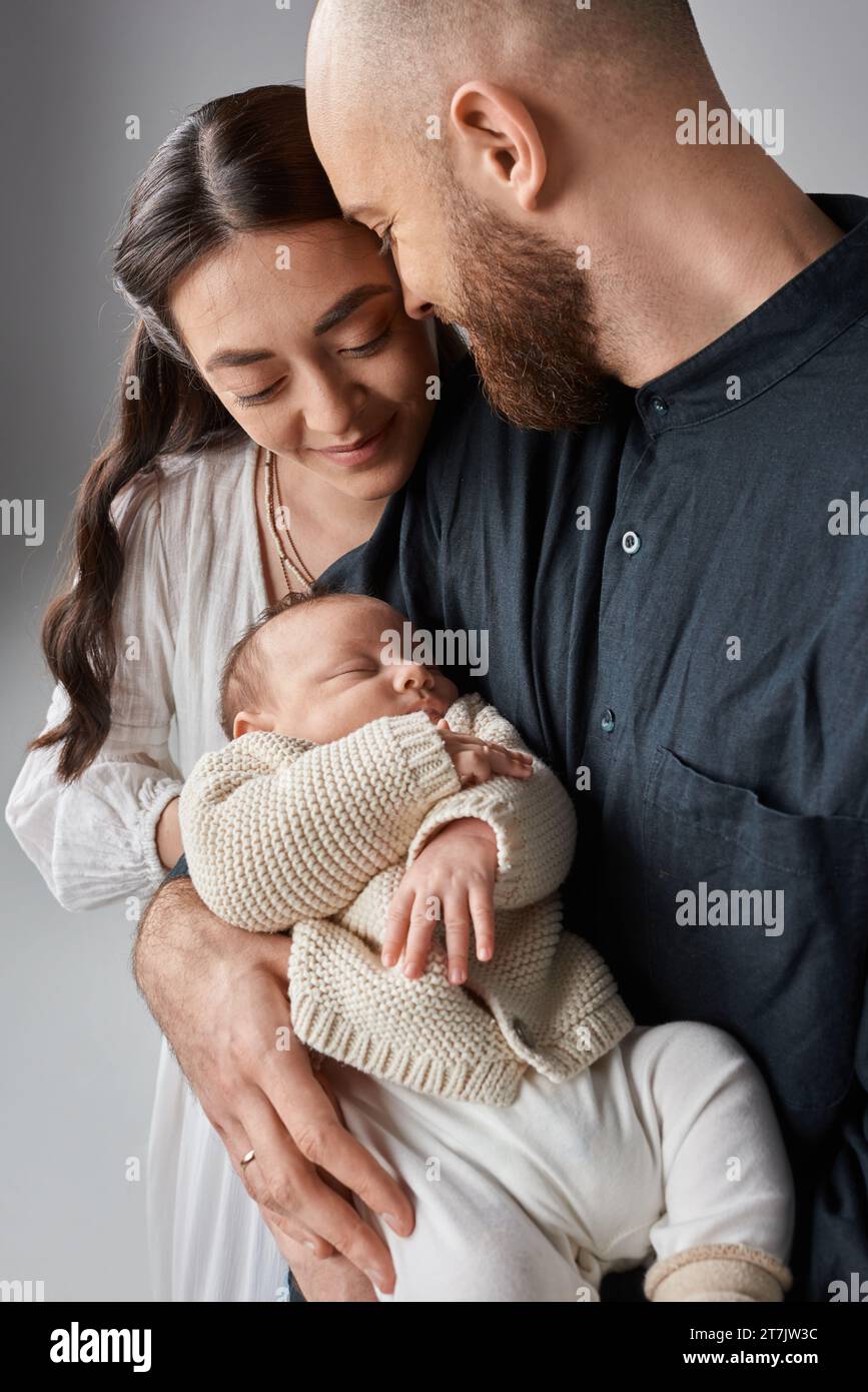vertical shot of happy loving family looking at their cute newborn baby boy, modern parenting Stock Photo