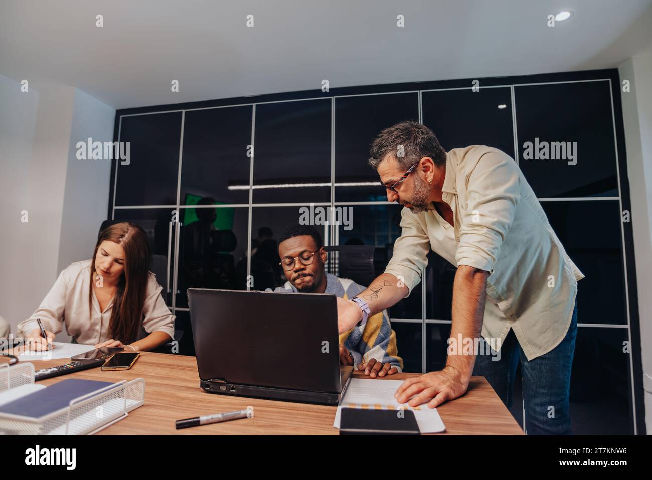 Diverse professionals in a modern boardroom collaborate, brainstorm, and develop project plans. Stock Photo