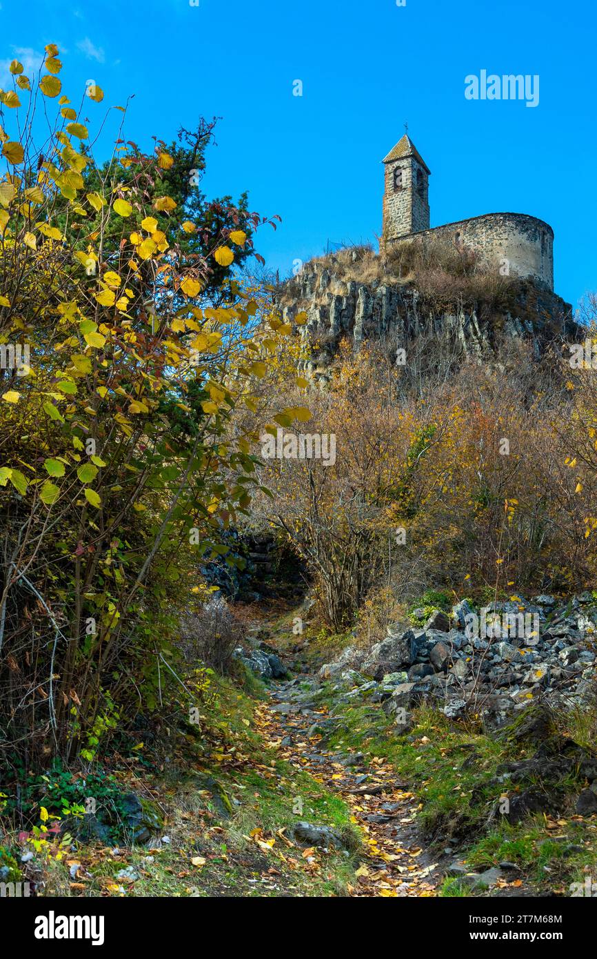 View from below of Brionnet chapel around Saurier village on volcanic peak, Puy de Dome department. Auvergne-Rhone-Alpes, France Stock Photo