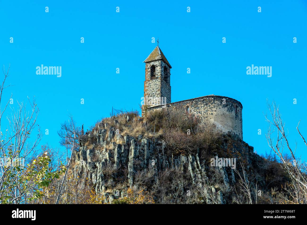 View from below of Brionnet chapel around Saurier village on volcanic peak, Puy de Dome department. Auvergne-Rhone-Alpes, France Stock Photo