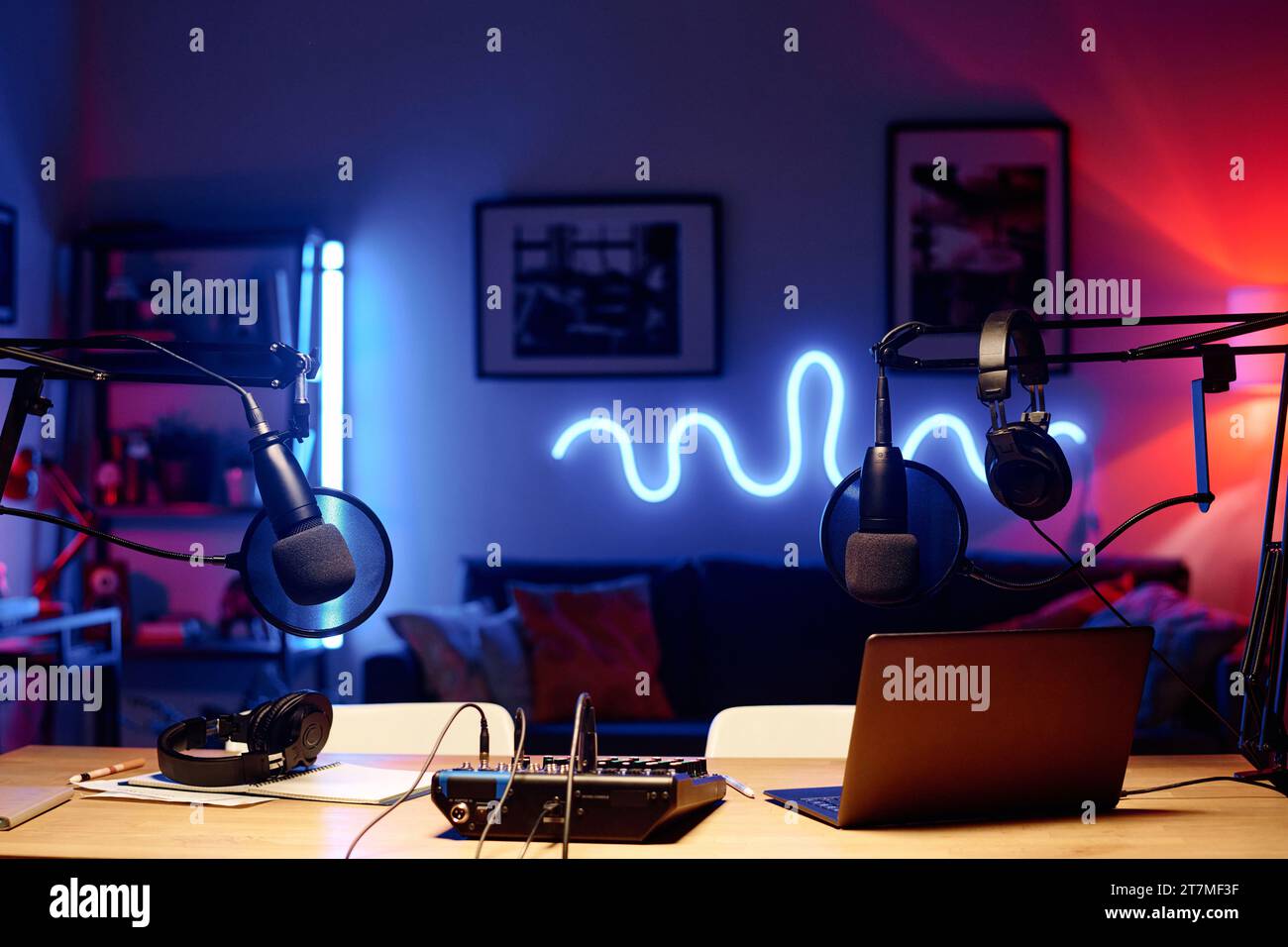 Laptop surrounded by microphones with headphones and soundboard