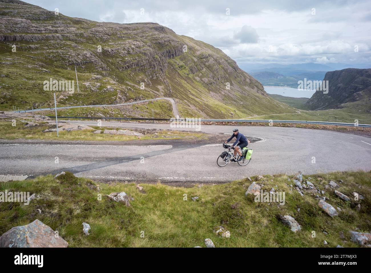 Cyclist near the top of the Bealach na Bà mountain pass near Applecross Scotland Stock Photo