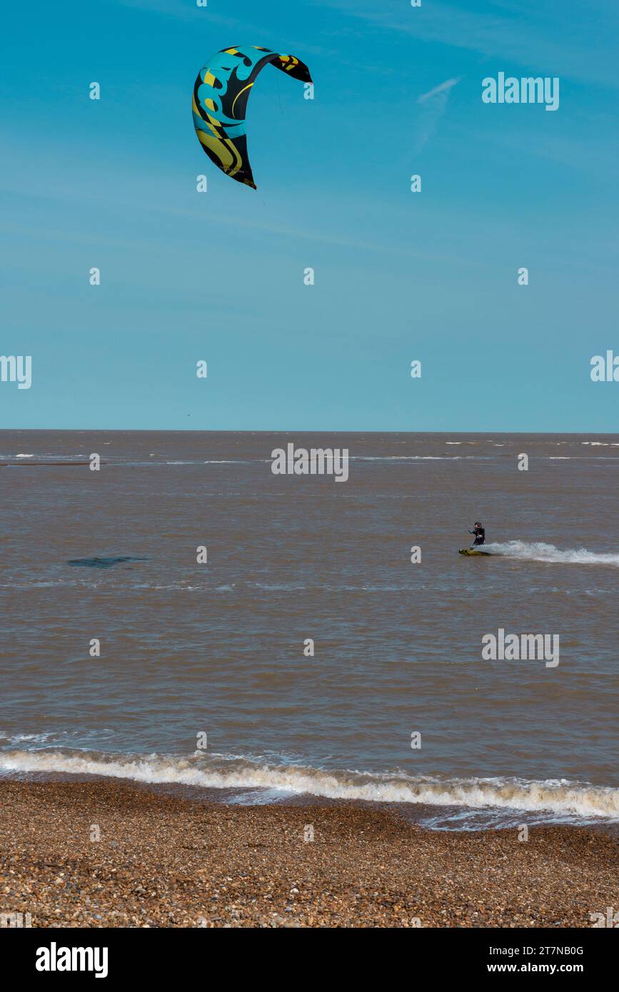 Windsurfers enjoy time on the water on a windy day in Shingle Street on the coast in Suffolk in England UK Stock Photo