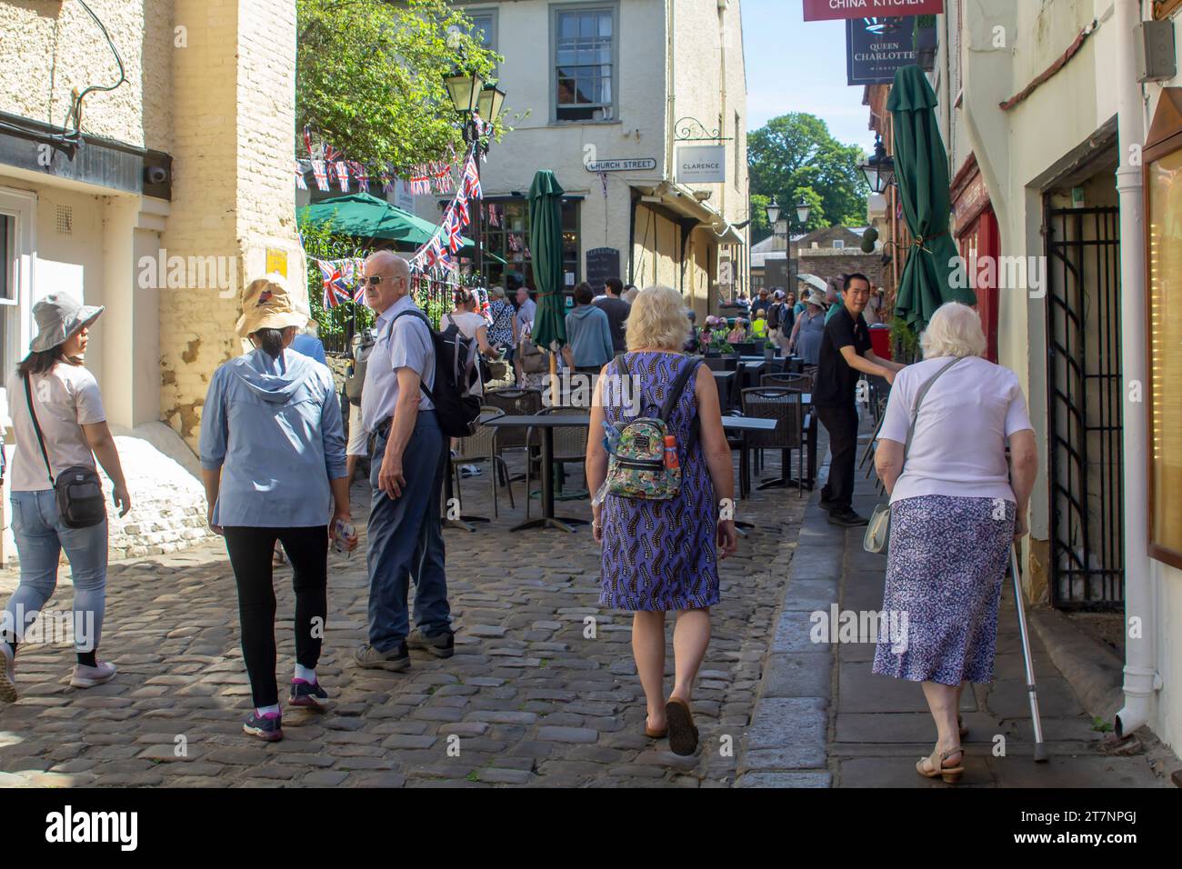15 June 2023 Customers and tourists iaround the local tea rooms and cafes in the busy Church Lane, Royal Windsor, Berkshire on a fine summer afternoon Stock Photo