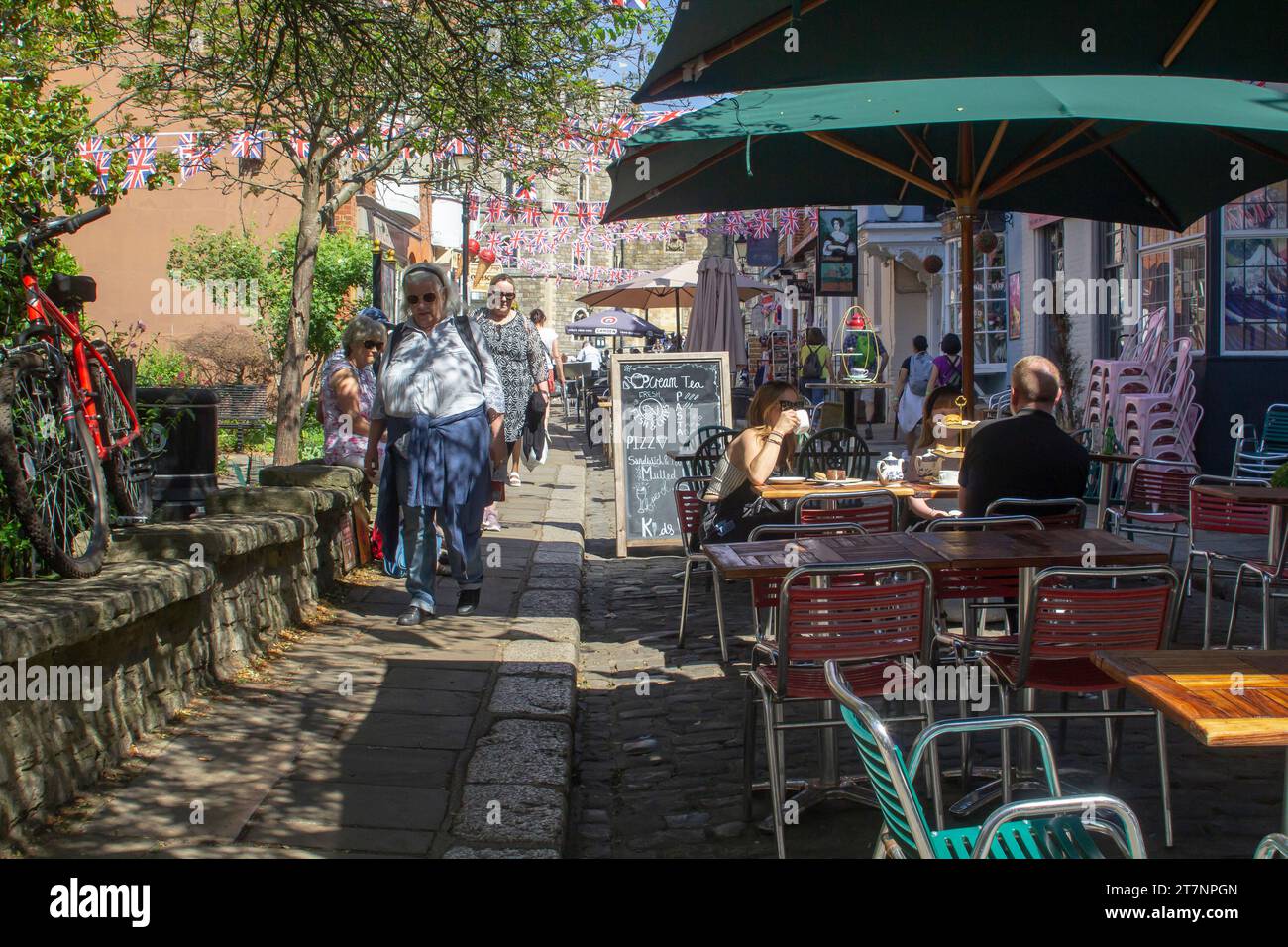 15 June 2023 Customers relax in the local tea rooms in Church Street, Royal Windsor, Berkshire on a fine summer afternoon. The Royal Residence of Wind Stock Photo