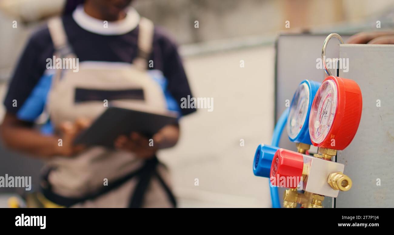 Close up of licensed serviceman calibrating ac gauges vacuum pump