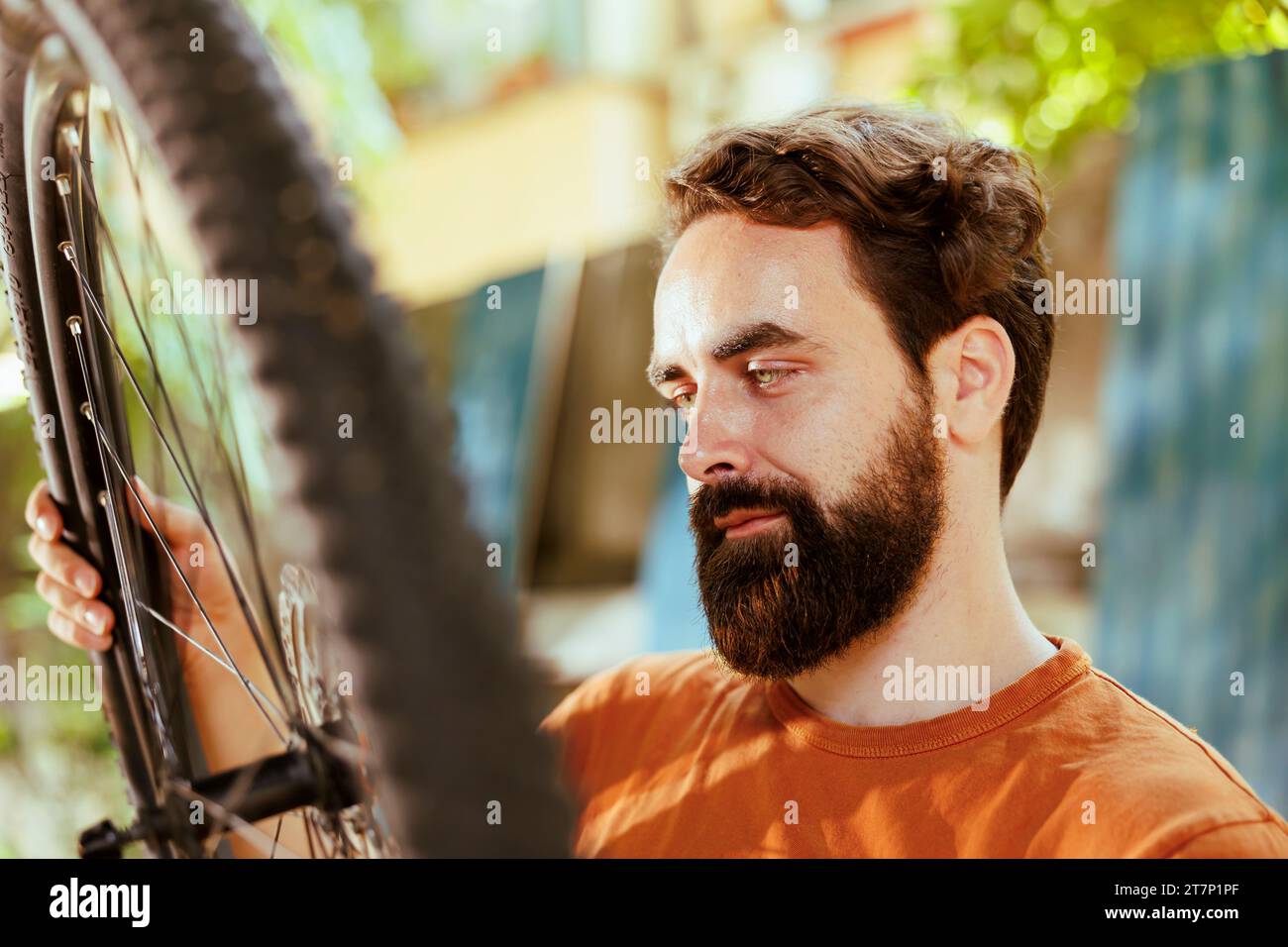 Active male cyclist checking tire as yearly bike rubber maintenance ...