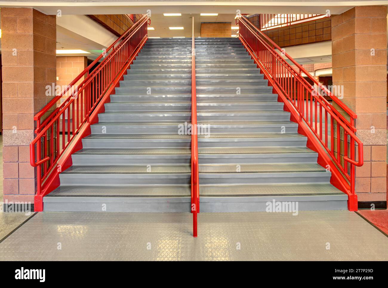 Anti slip floor treads and safety railings on the steps of an elementary school stairway. Stock Photo