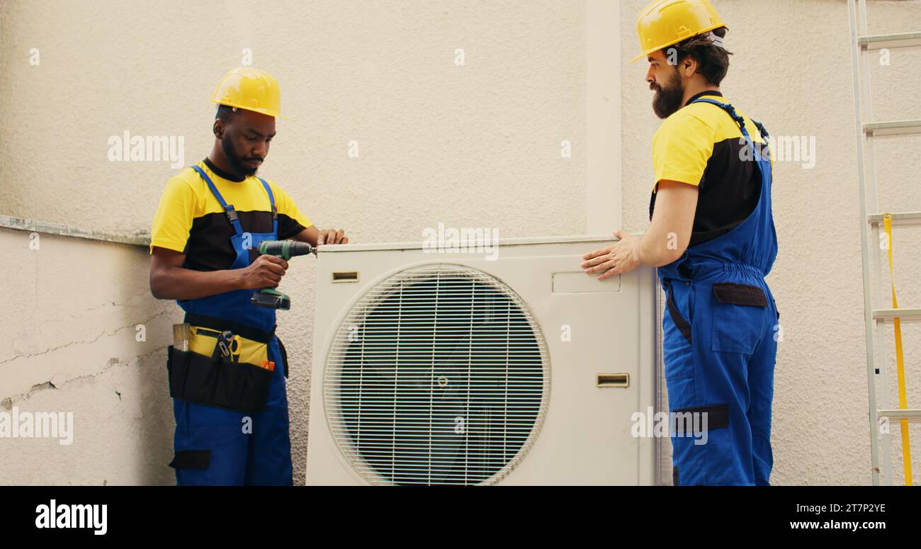 Engineering colleagues opening up rusty out of service air conditioner