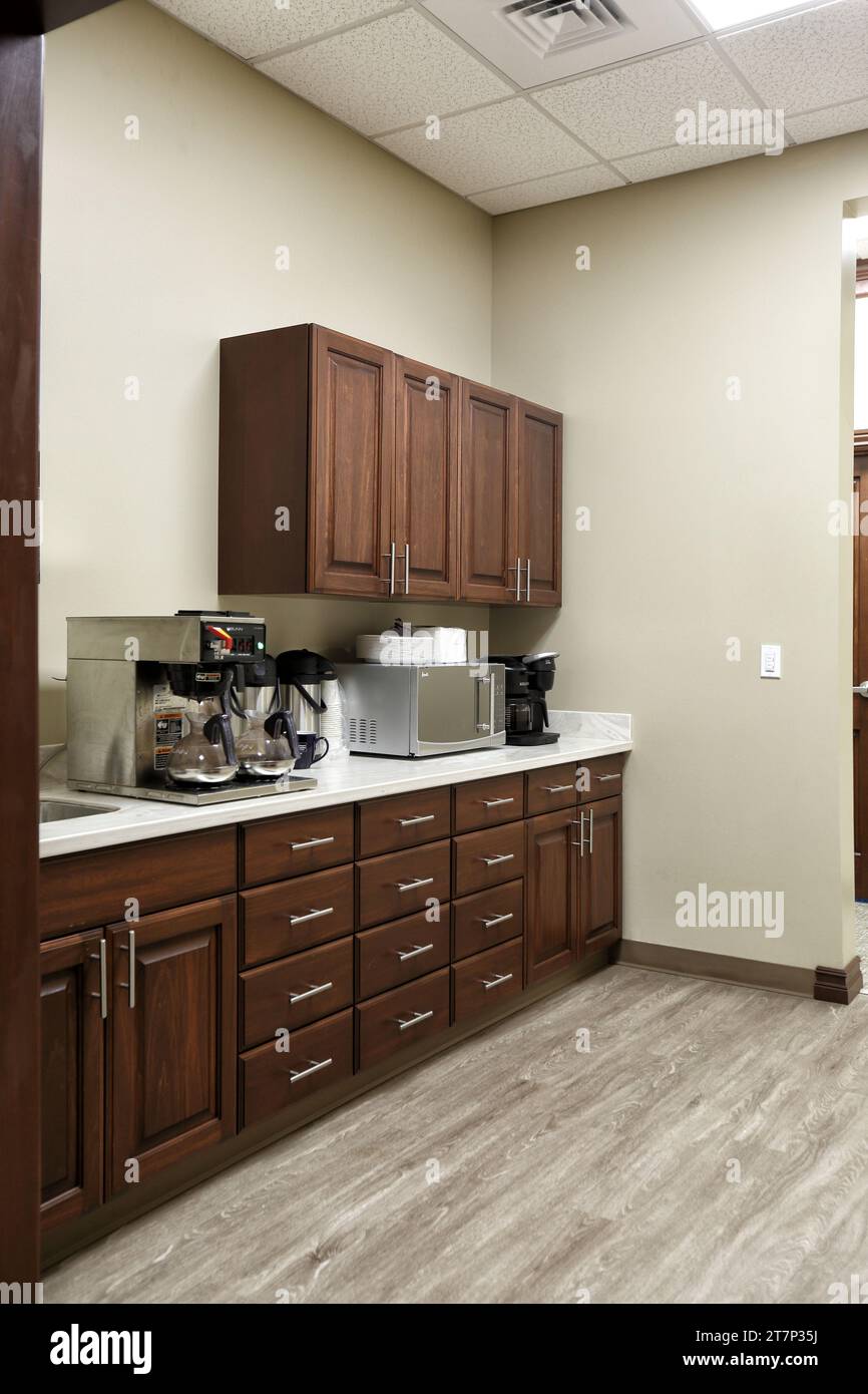 A modern break room in a small office building, with coffee maker, cabinets, and microwave. Stock Photo