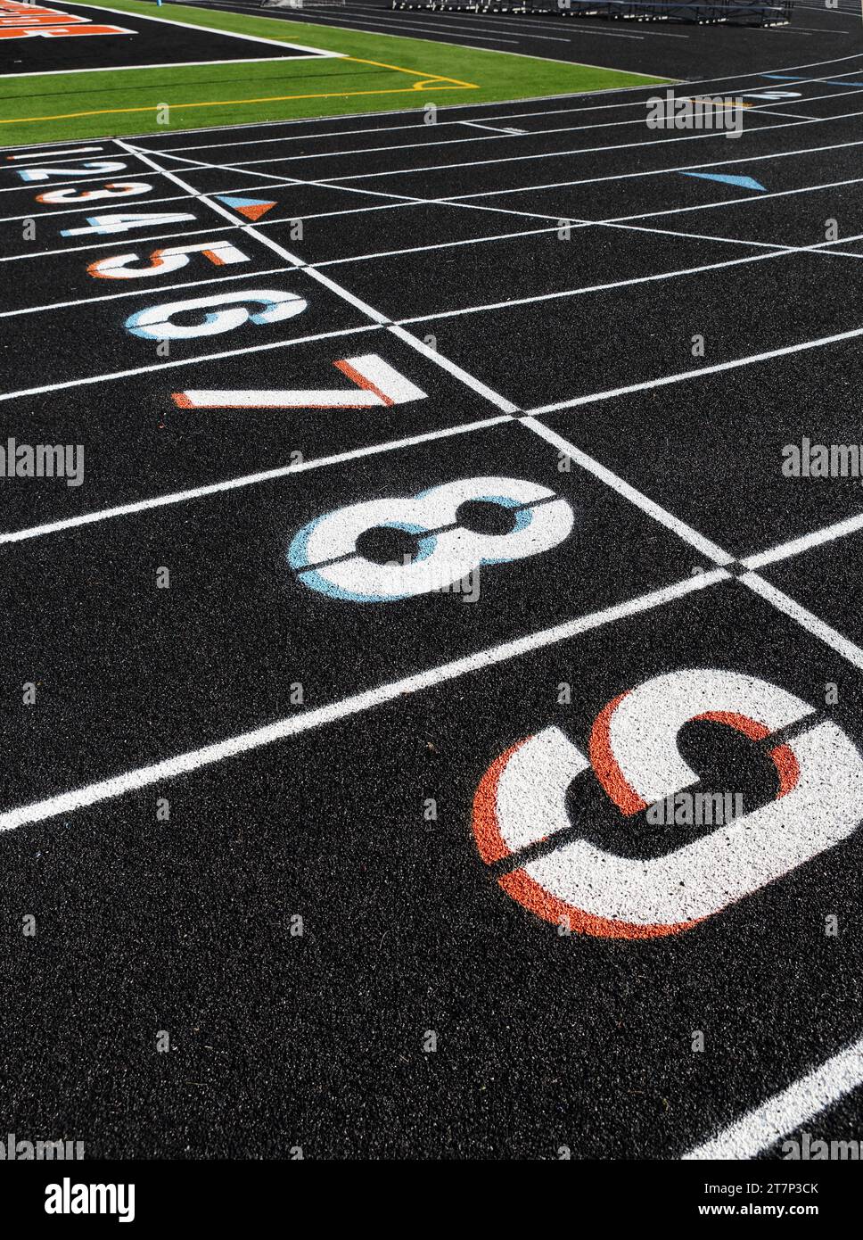 The black surface and lane markings on a newly installed high school sports track, made from recycled tires. Stock Photo