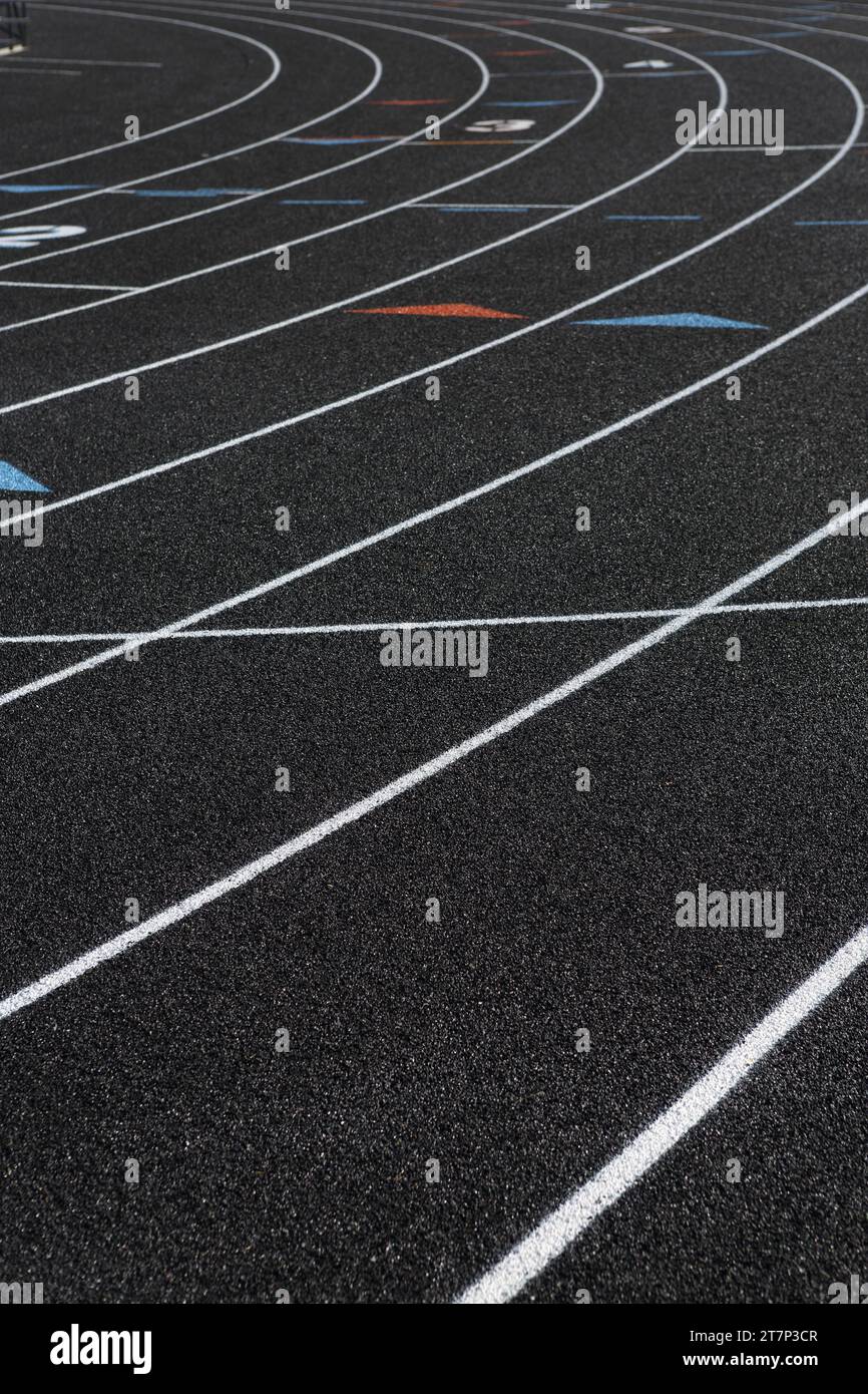 The black surface and lane markings on a newly installed high school sports track, made from recycled tires. Stock Photo