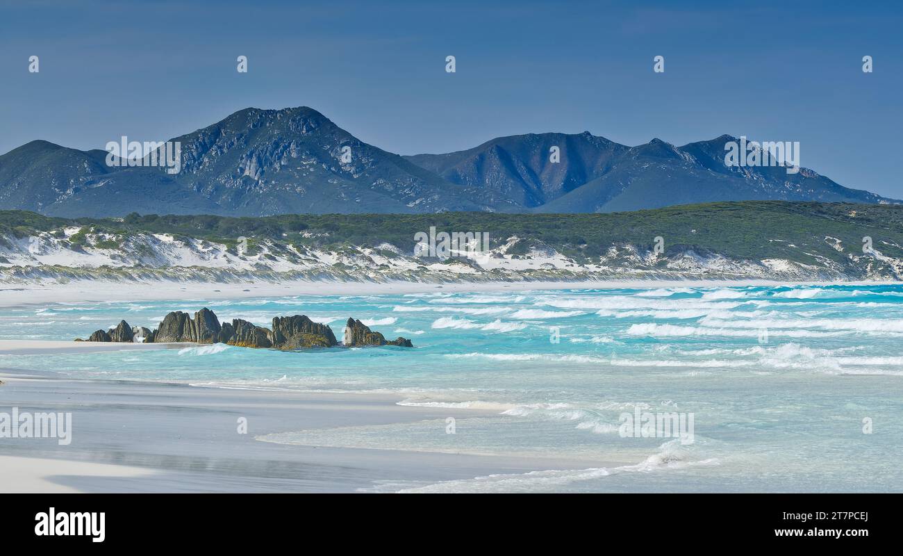 Rock stacks & eroded rock on sandy beach with Mount Barren range at Point Charles Bay, Fitzgerald River National Park, Western Australia, Australia Stock Photo