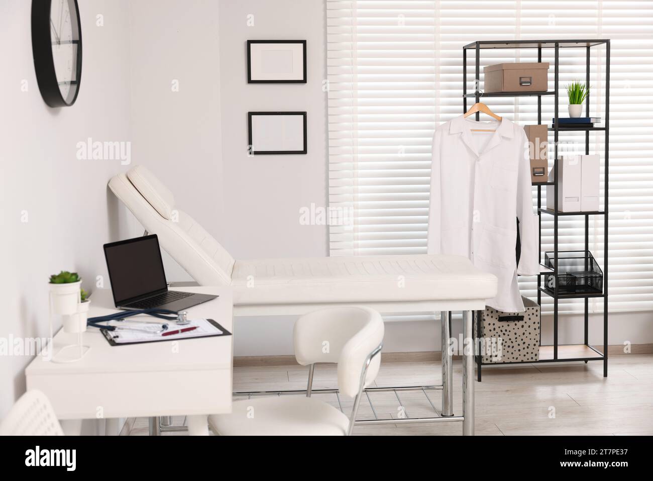 Modern medical office with doctor's workplace and examination table in ...