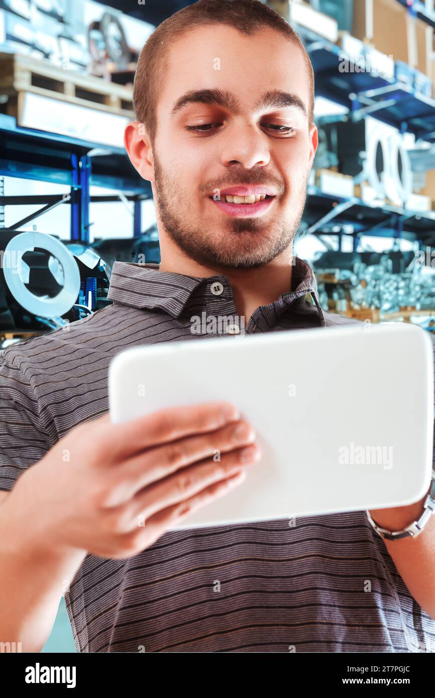 Tech-savvy worker happily engaging with digital inventory system Stock Photo