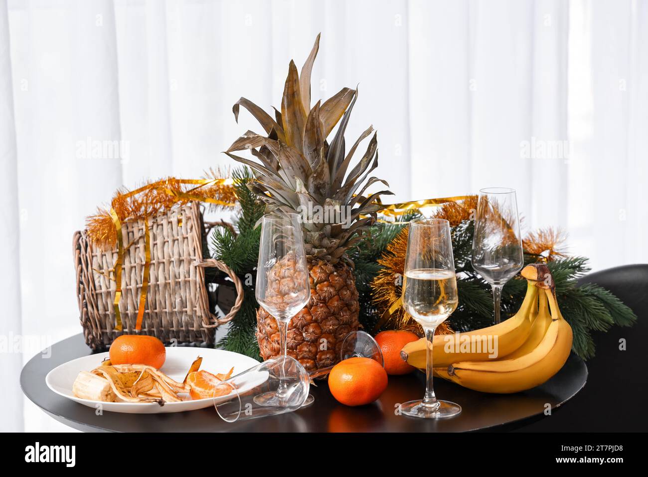 Christmas tree with food and drink on table in messy room after New