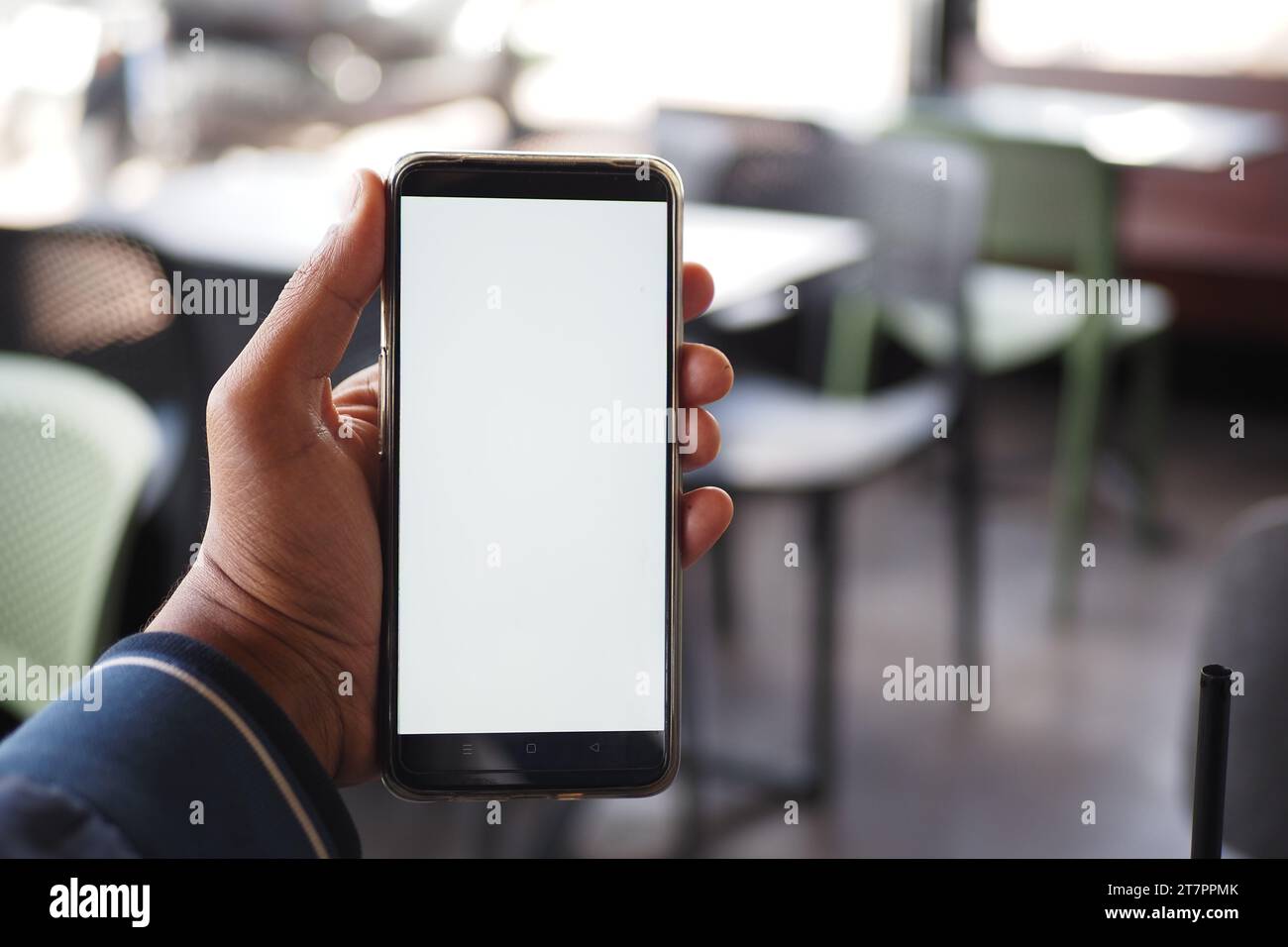 young man hand using smart phone with white screen at cafe background  Stock Photo