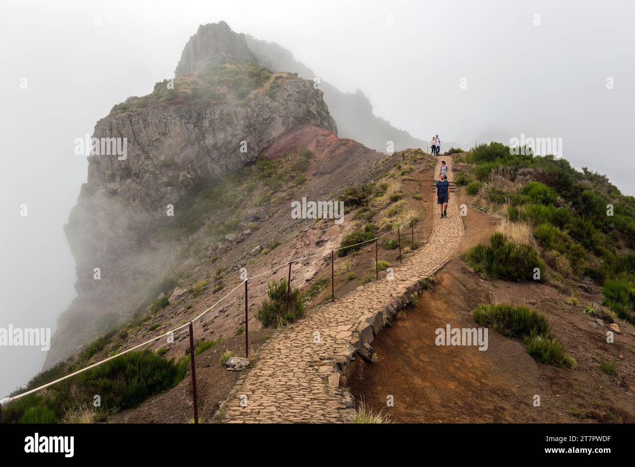 Hikers on the PR1 Vereda do Areeiro hiking trail in the fog, from Pico do Arieiro to Pico Ruivo