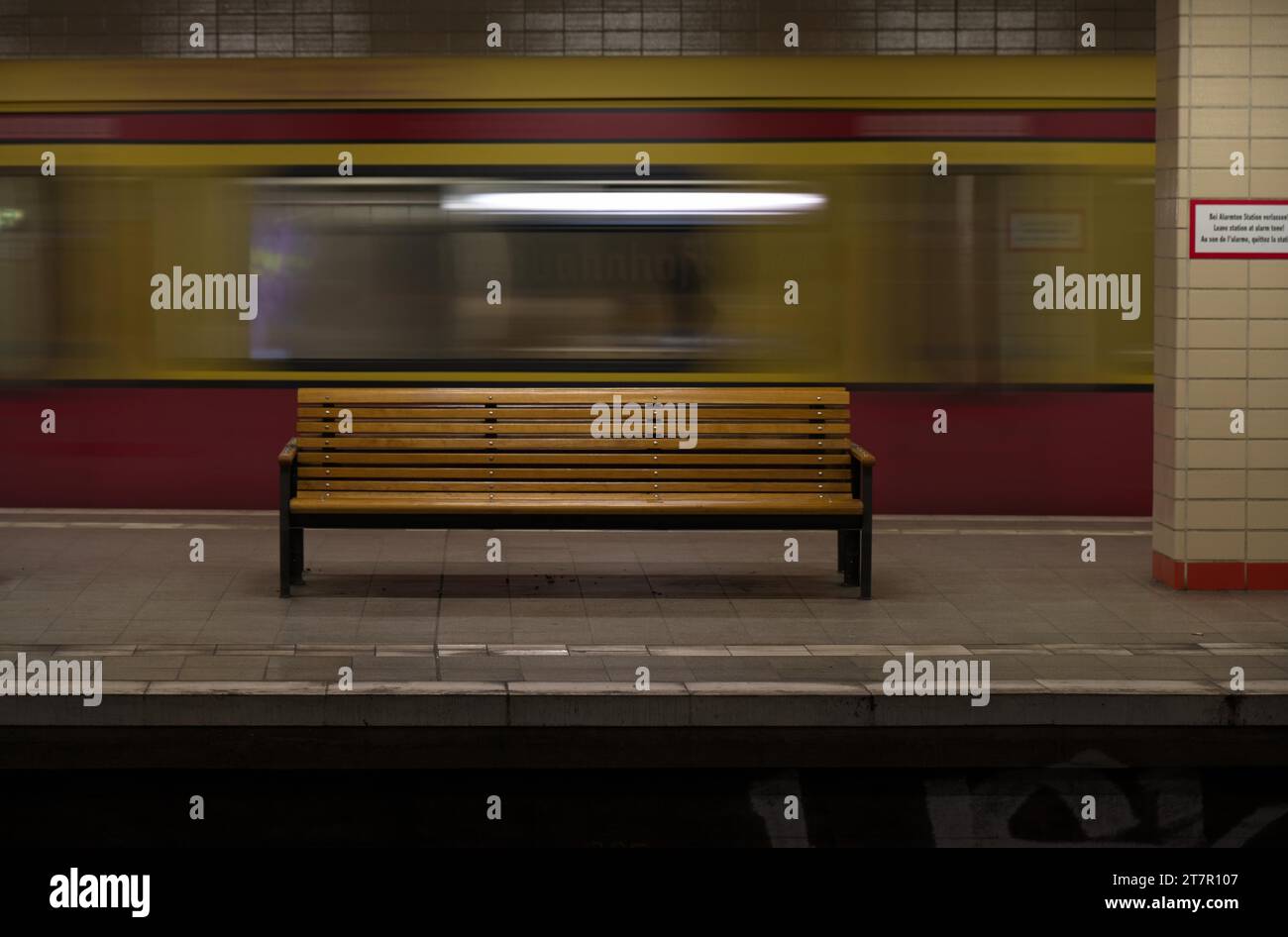 Empty bench and departing S-Bahn train at Nordbahnhof, Mitte district, Berlin, Germany Stock Photo