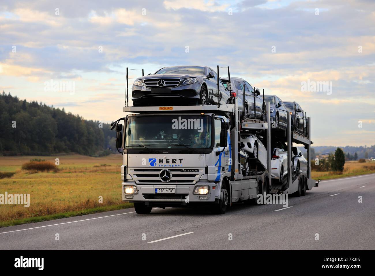 Mercedes-Benz car carrier truck Hert Transport hauls new cars along highway in South of Finland early in autumn morning. Salo, Finland. Sept 23, 2022 Stock Photo