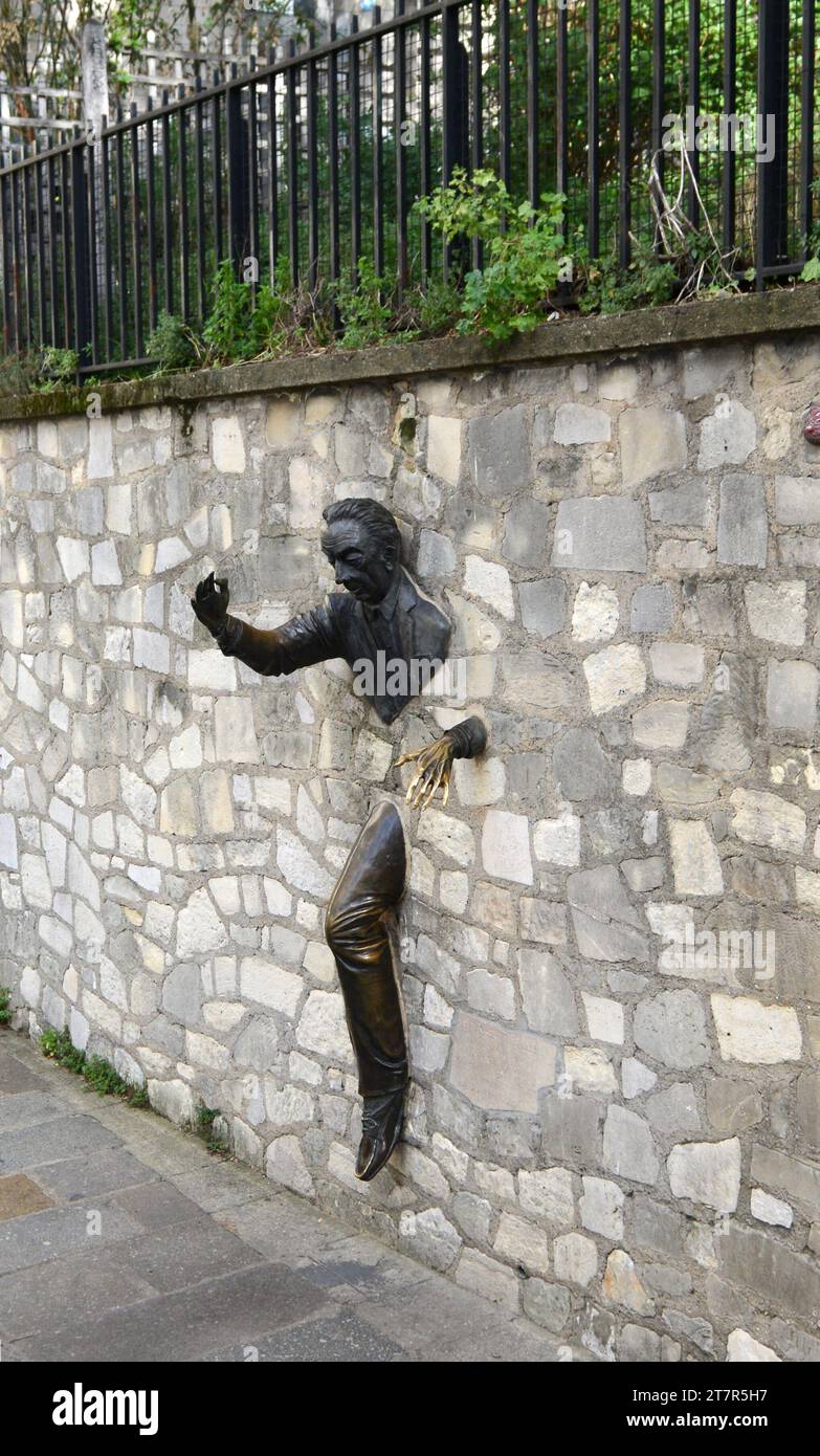 Le Passe-Muraille is a Unusual sculpture of a man embedded in a wall, based on a story by French writer, Marcel Aymé. Montmartre, Paris, France. Stock Photo