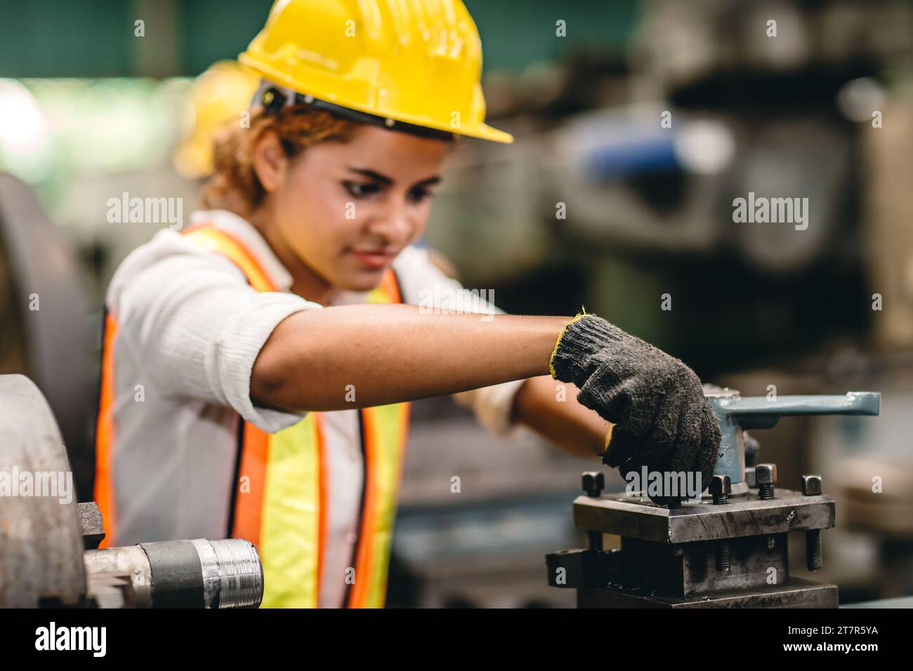 Engineer milling technician African woman worker manual hand skill working in heavy industry control metal lathe machine Stock Photo