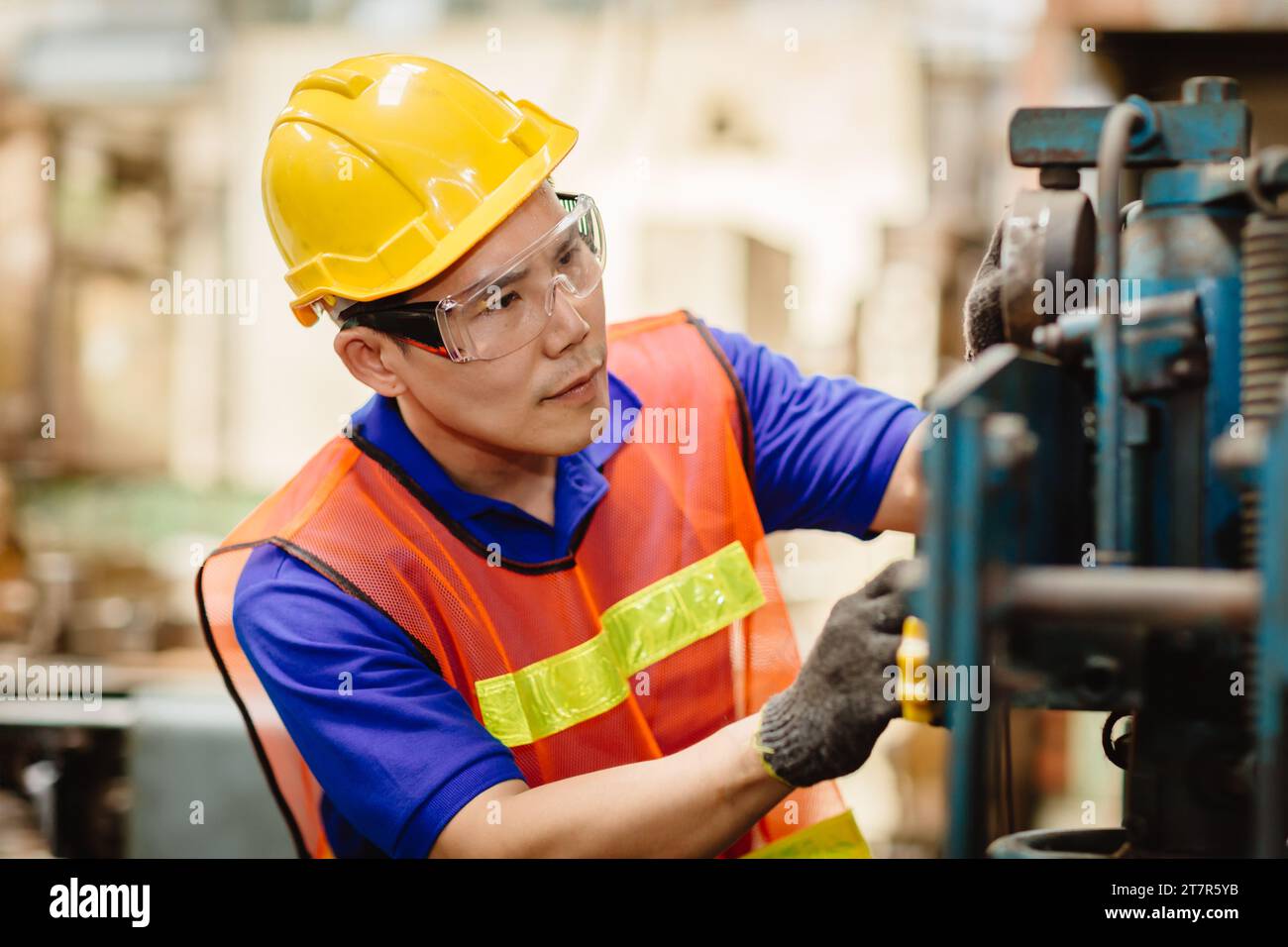Engineer milling technician male worker Asian chinese manual hand skill working in heavy industry control metal lathe machine Stock Photo