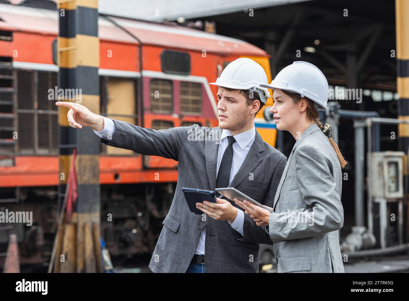 business investor engineer team working survey at site outdoor old locomotive depot diesel train yard plan for renovate Stock Photo